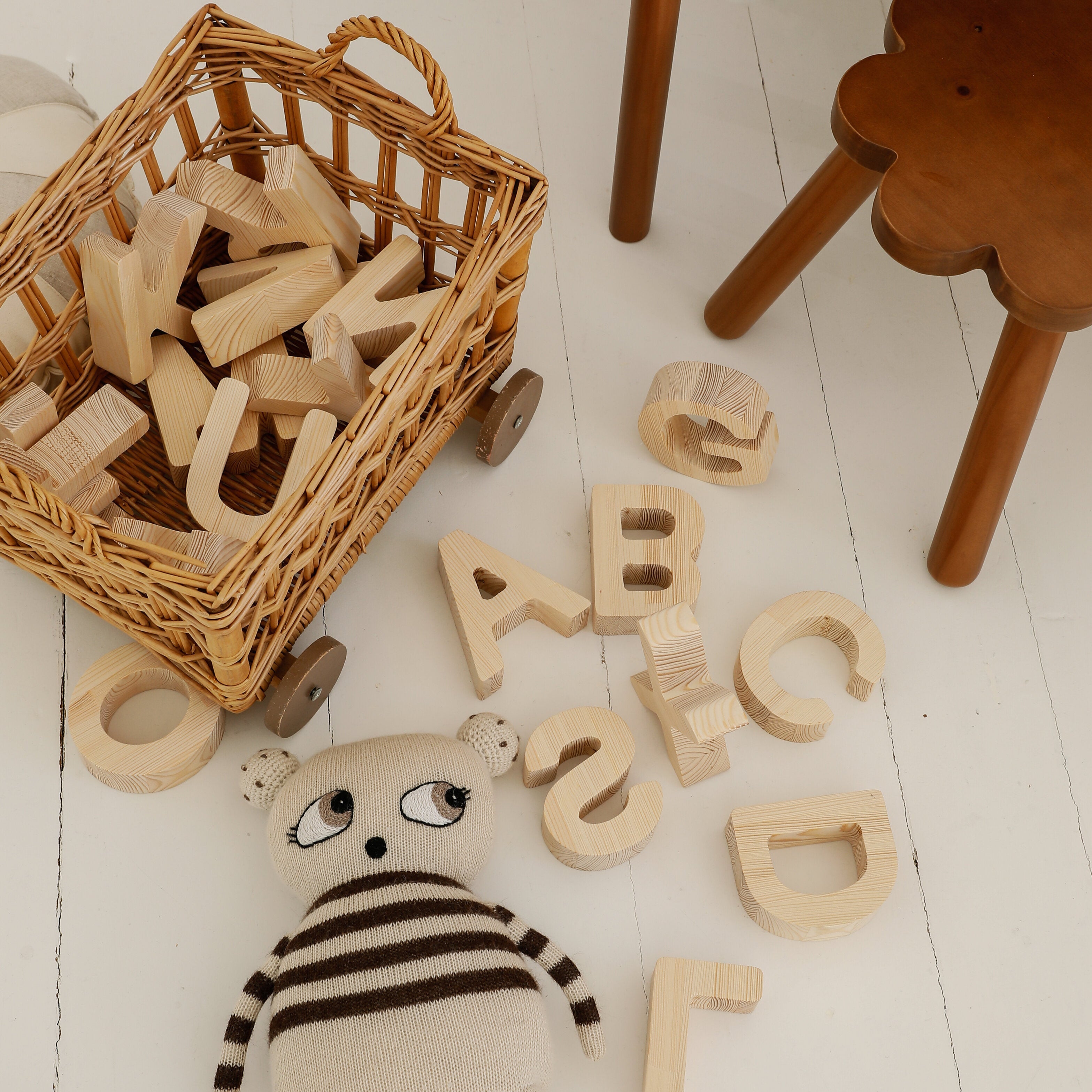 Close-up of wooden alphabet block showing smooth finish and natural pine grain.