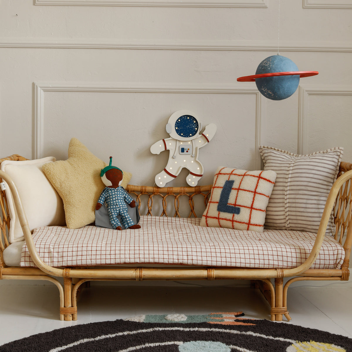 Space themed kids room with the Little Lights Astronaut by the daybed
