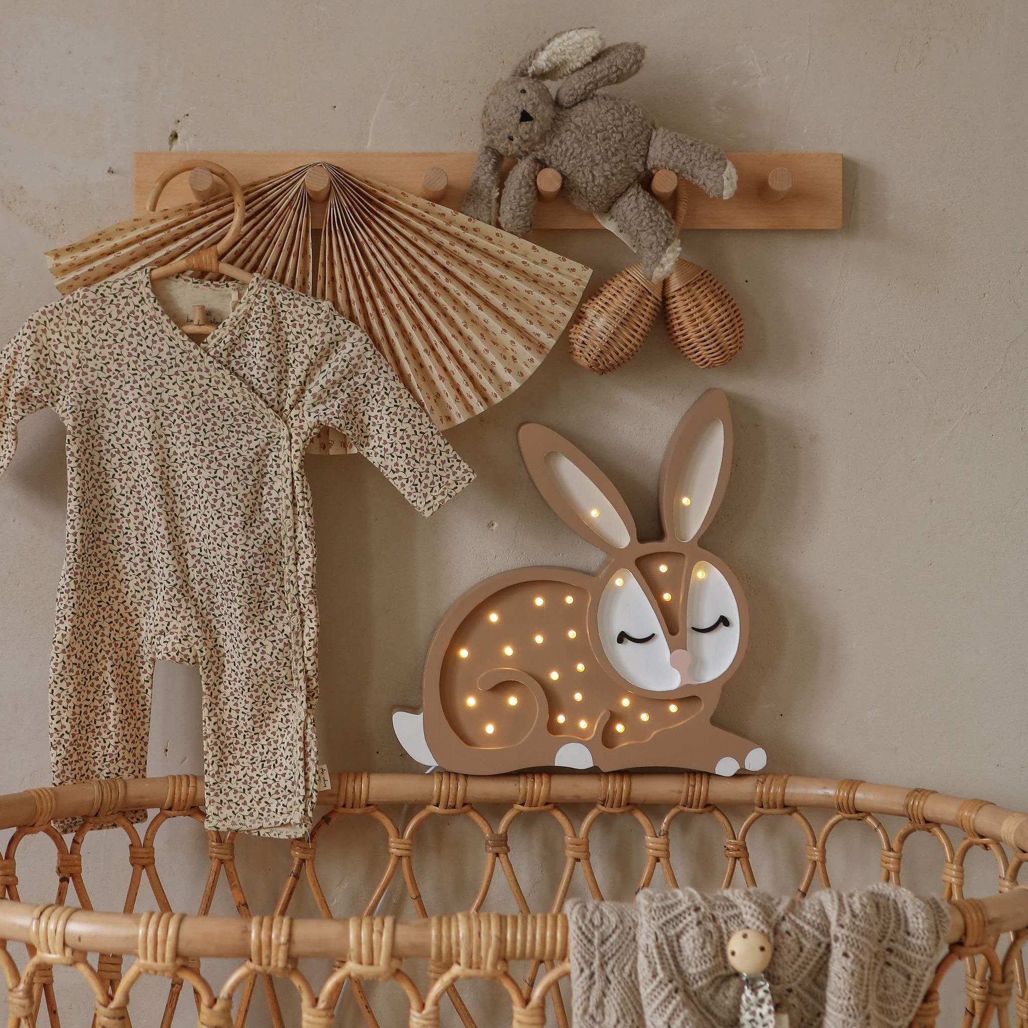 Little Lights Handmade Bunny Lamp next to a wicker crib in a baby nursery