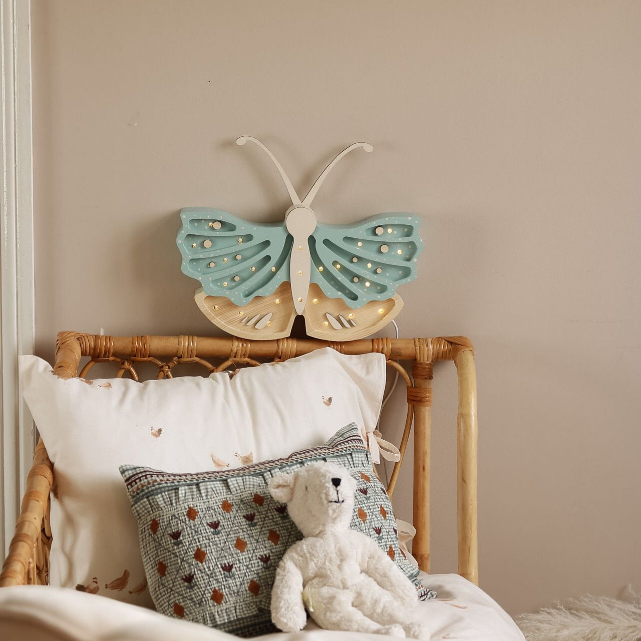 Little Lights blue Butterfly lamp dimmed by a child's bed