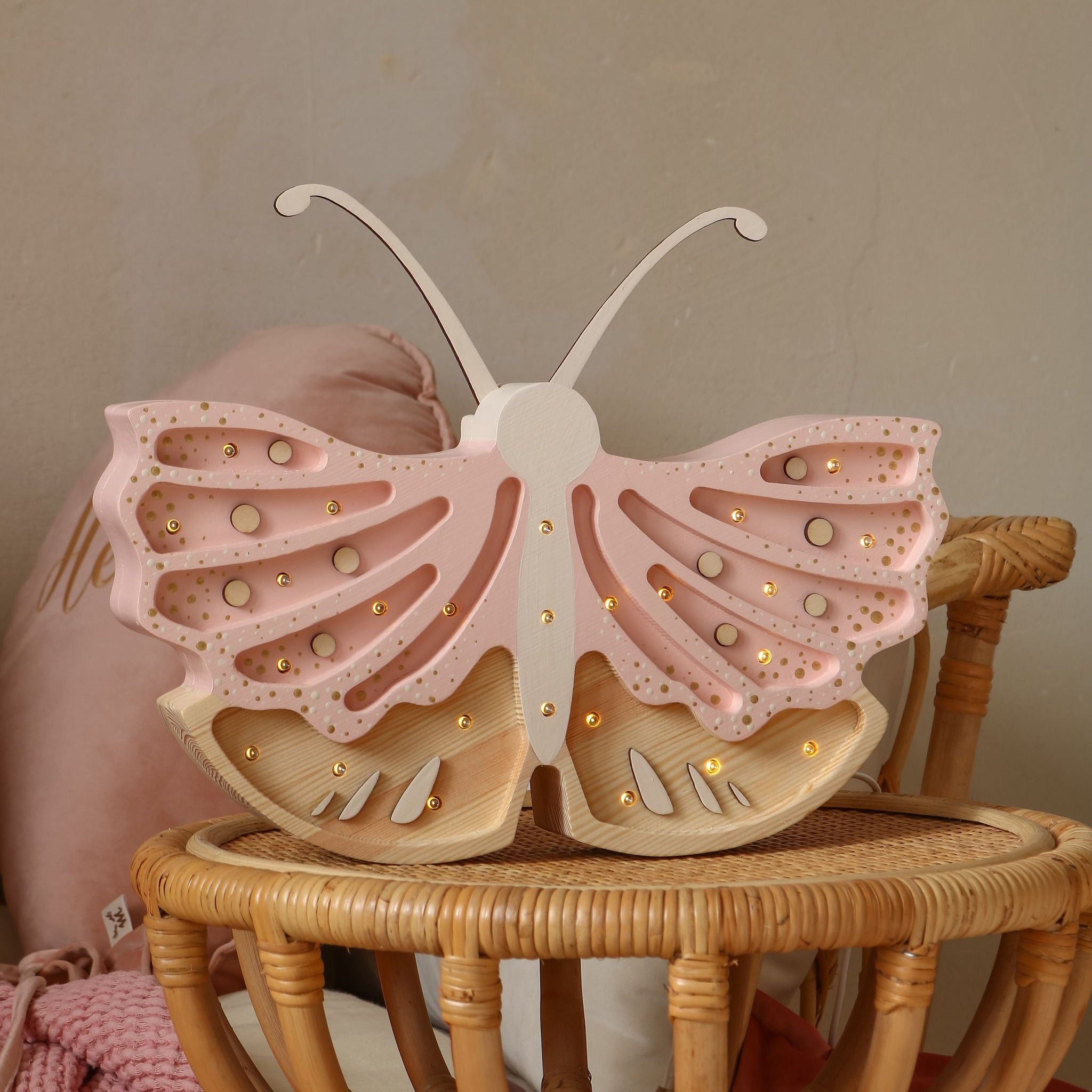 Little Lights Butterfly pink lamp on a wicker stool in a girl's room