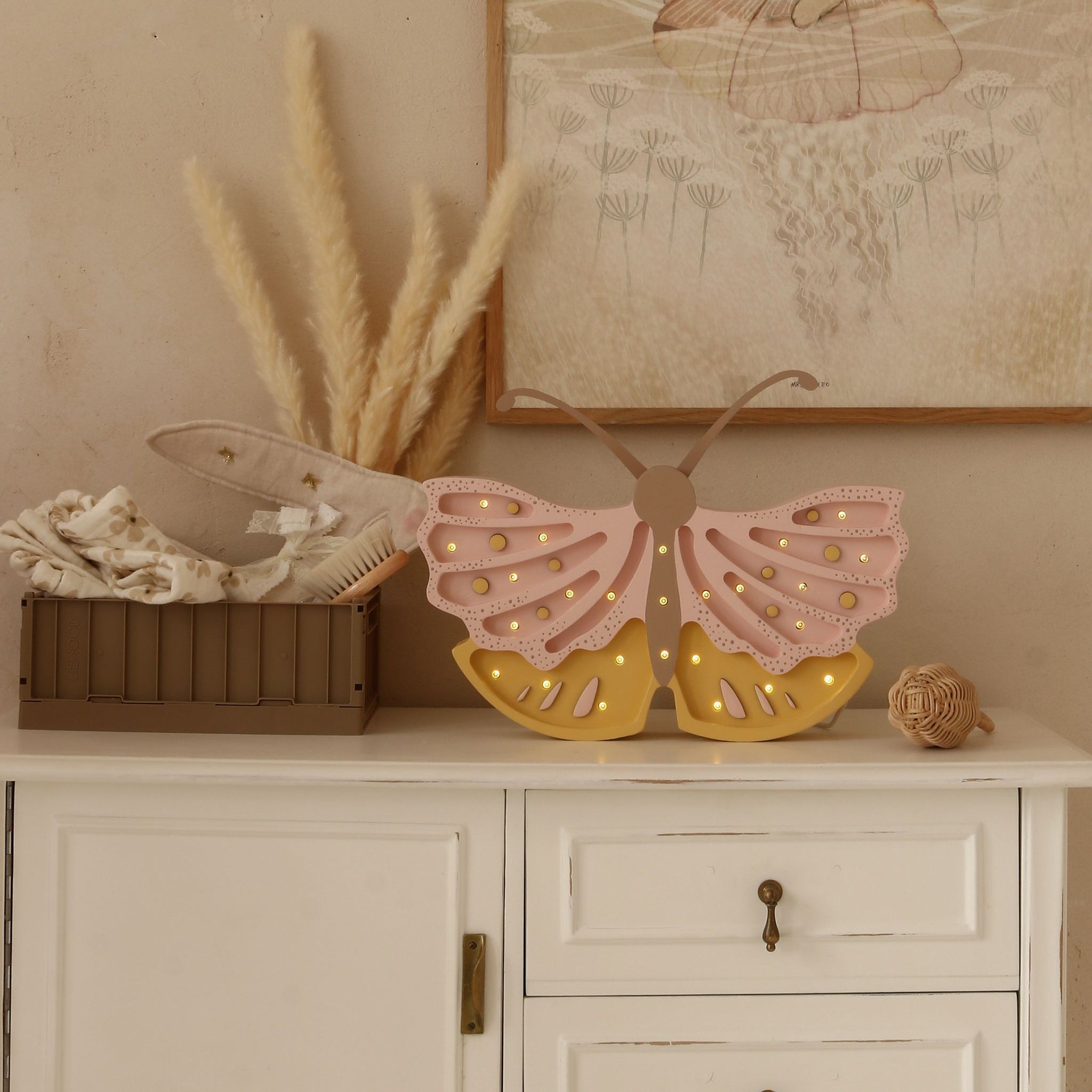 Little Lights Butterfly pick and yellow lamp on a dresser in a girl's room