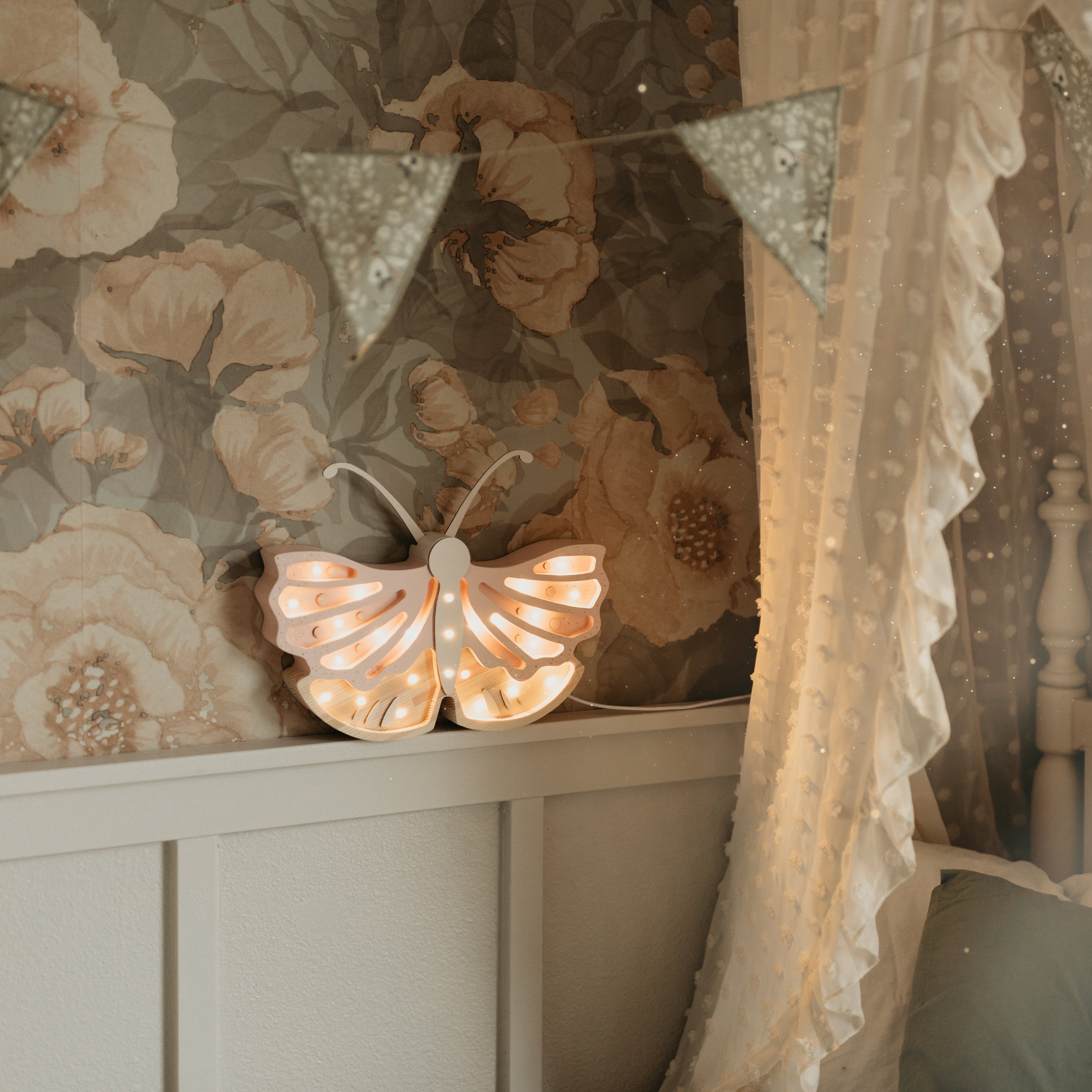 Little Lights Butterfly lamp next to a bed in a floral girl's room