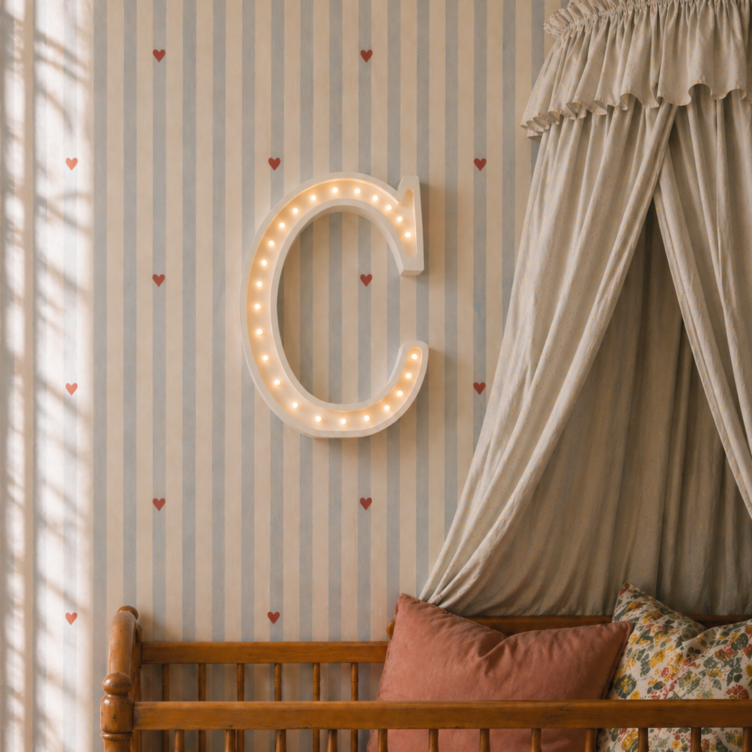 Little Lights C Letter Night Light hangin on the wall above a baby crib in a nursery