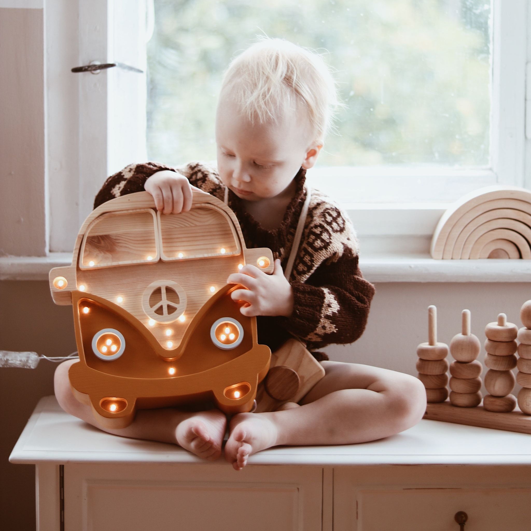 Little Lights Camper Van Lamp Mustard Wood next to a child in a boy's room