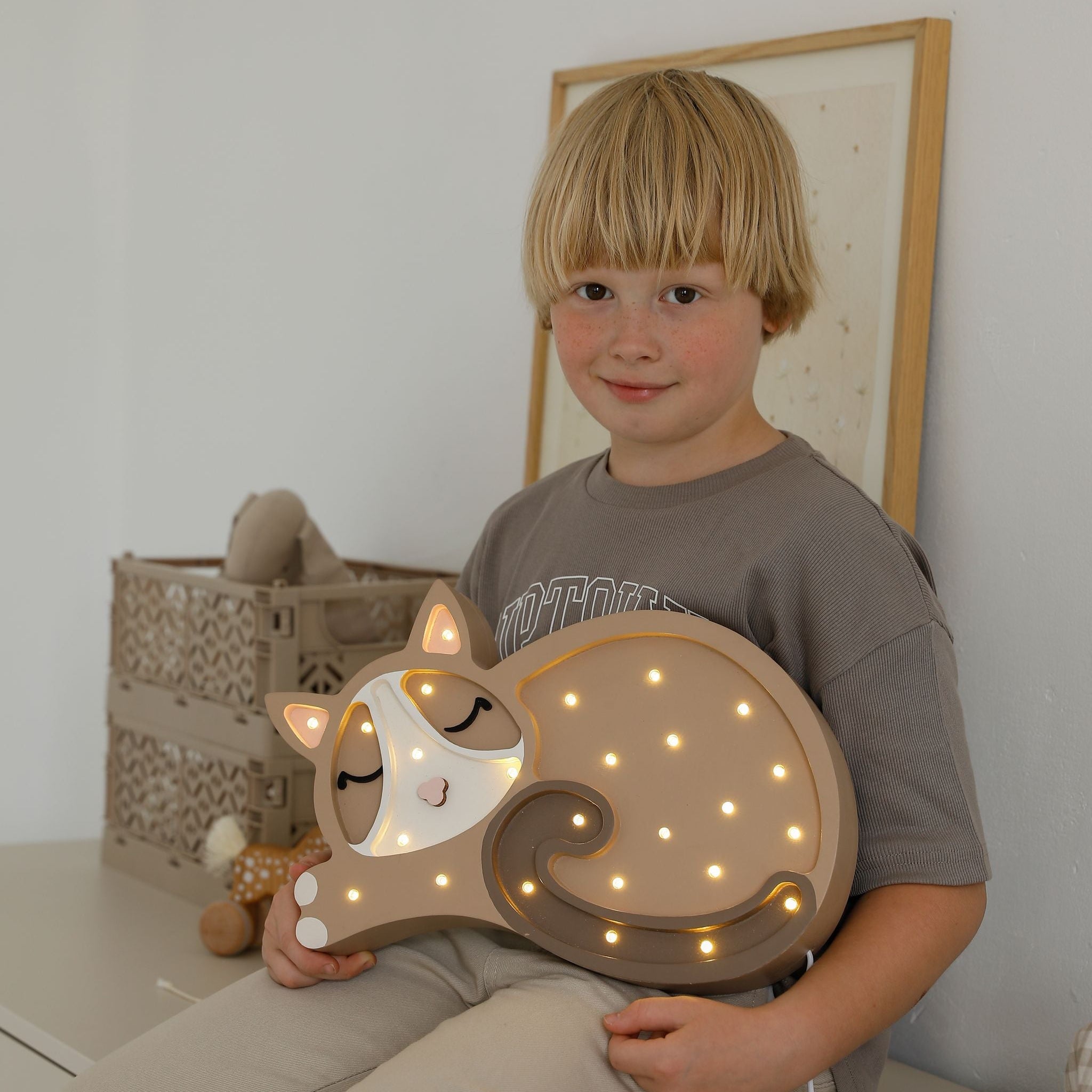 A child holding Little Lights Cat Lamp