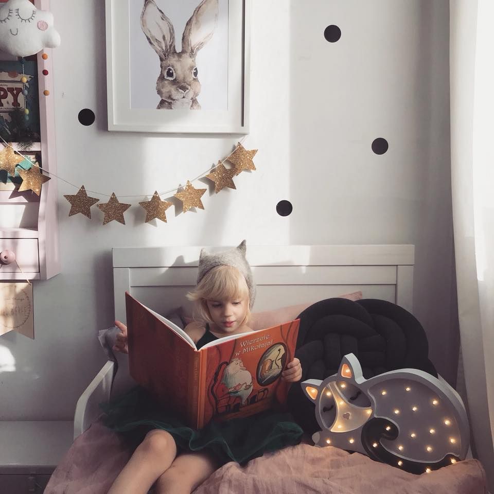 Girl reading a book next to the Little Lights Cat Lamp
