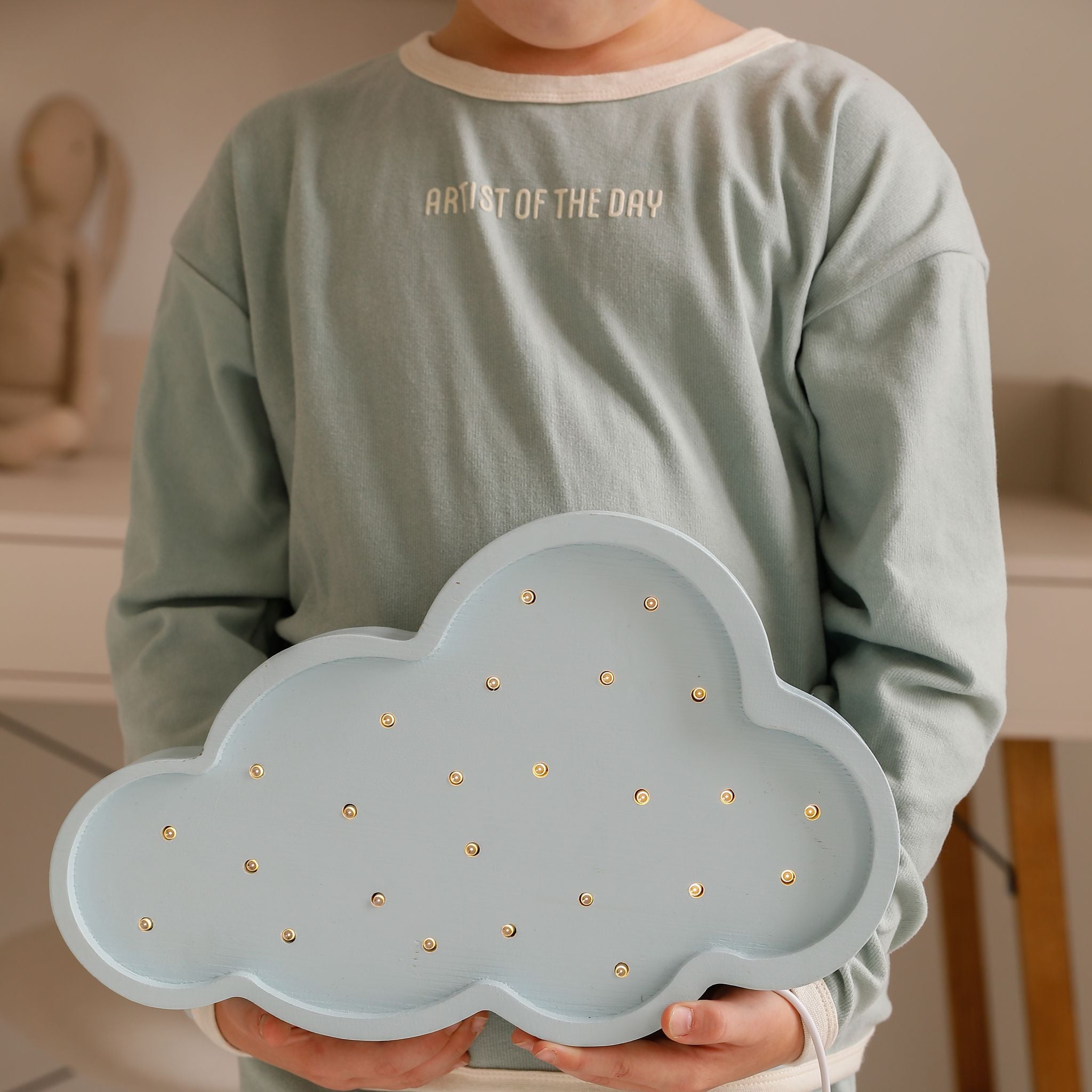 A Boy holding Little Lights Blue Cloud Night Light