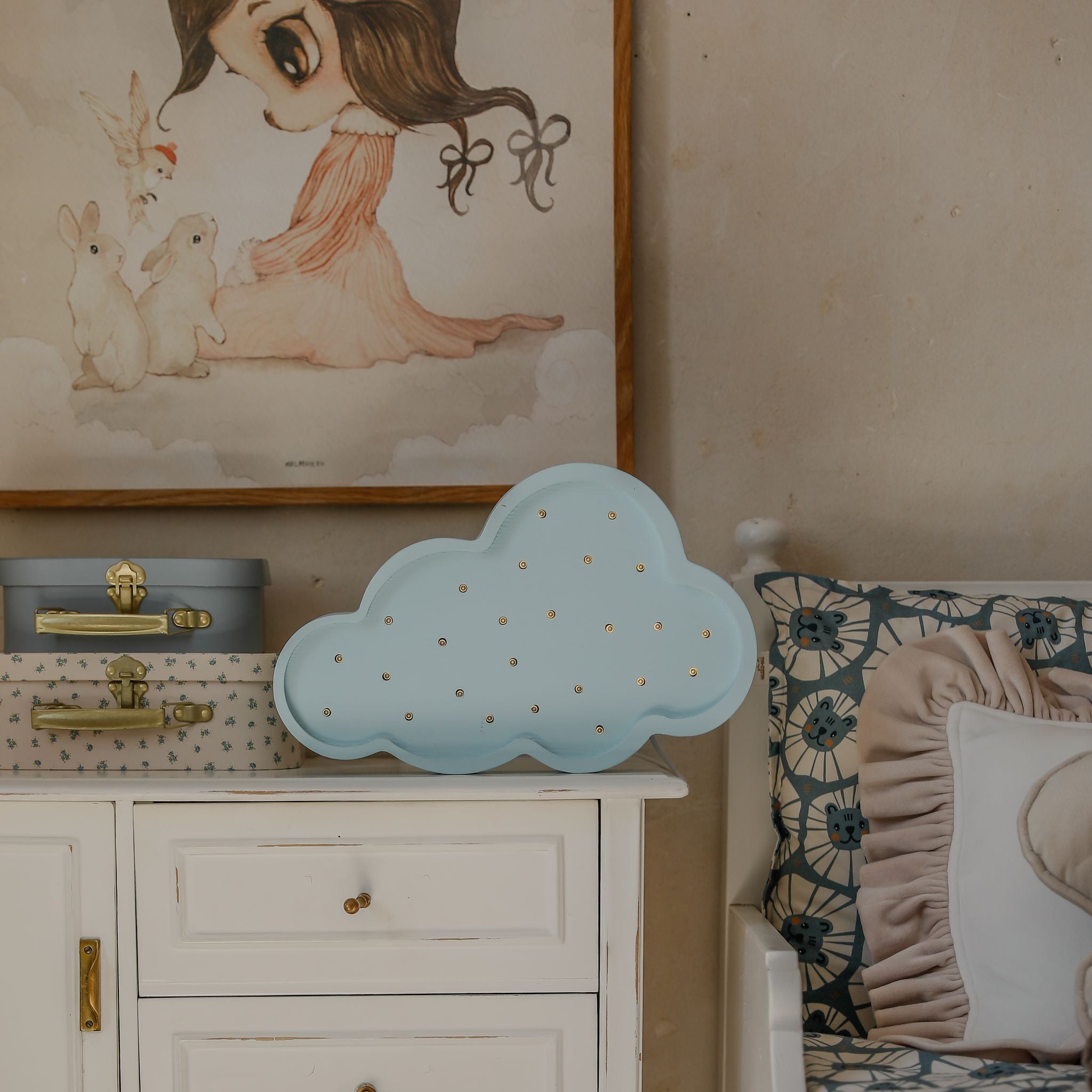 Little Lights Blue Cloud Night Light glowing in a kid's room. by the bed