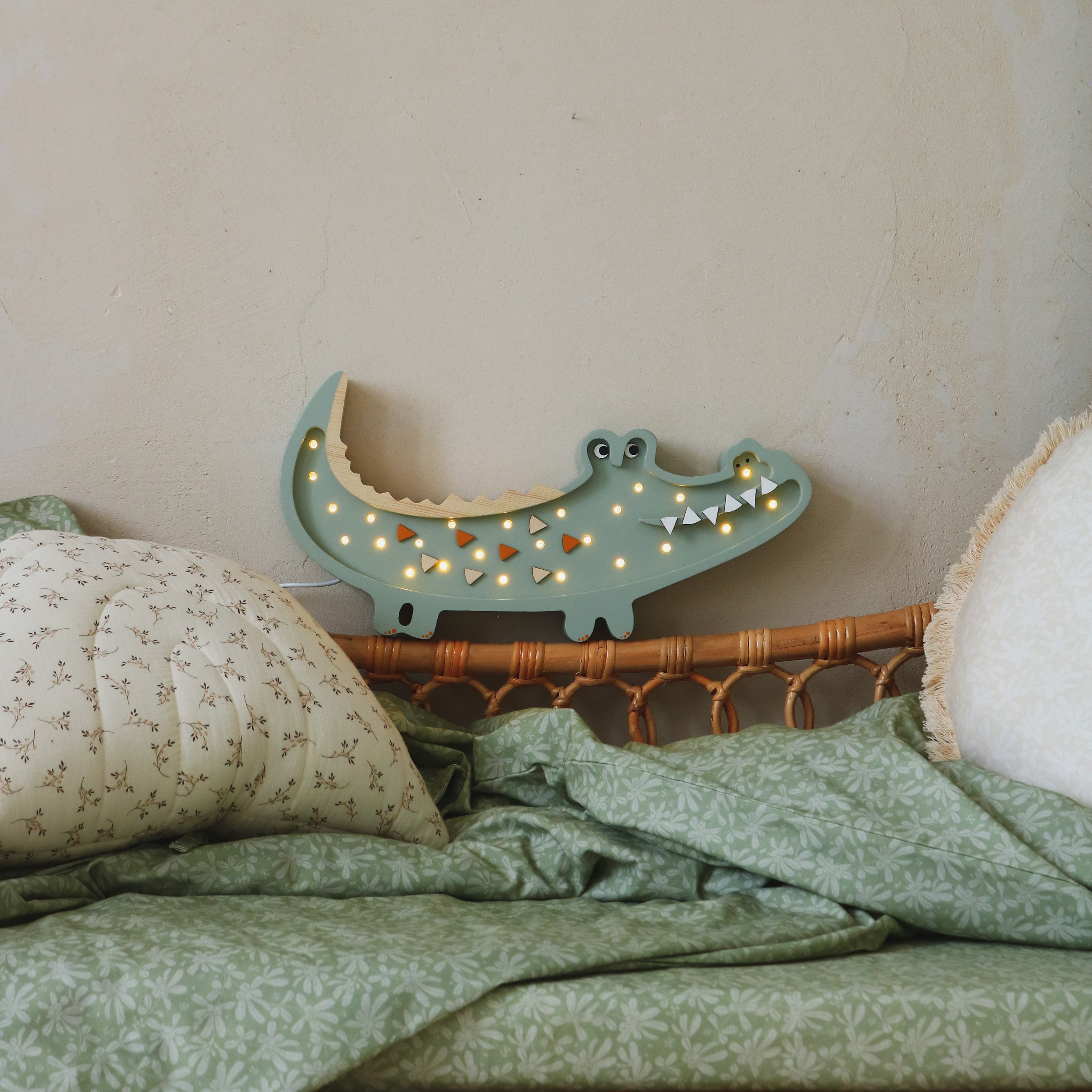 Wooden Crocodile Lamp in Pastel Khaki next to a bed in a child's room