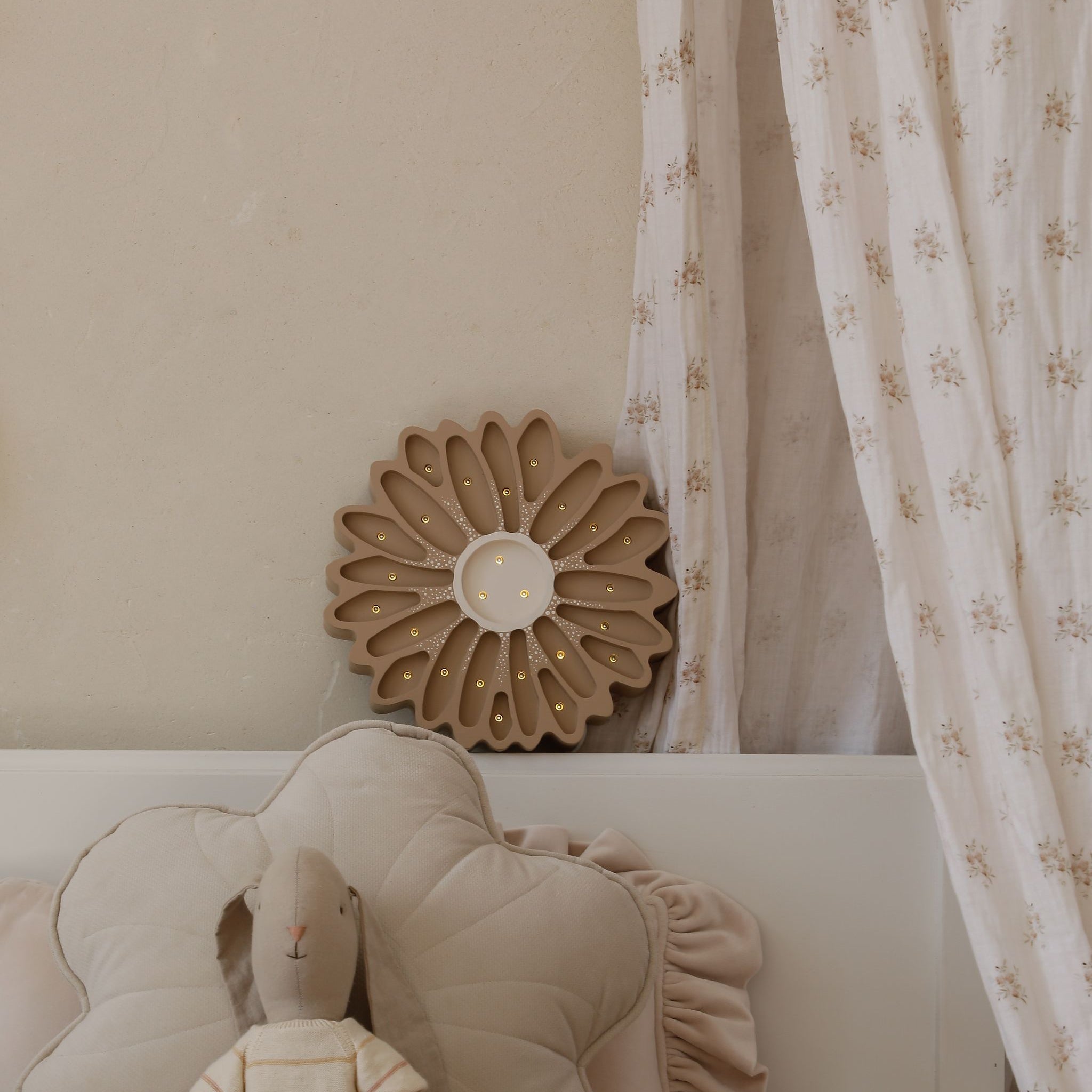 Little Lights Brown Flower Night Light glowing be a bed in a girl's room