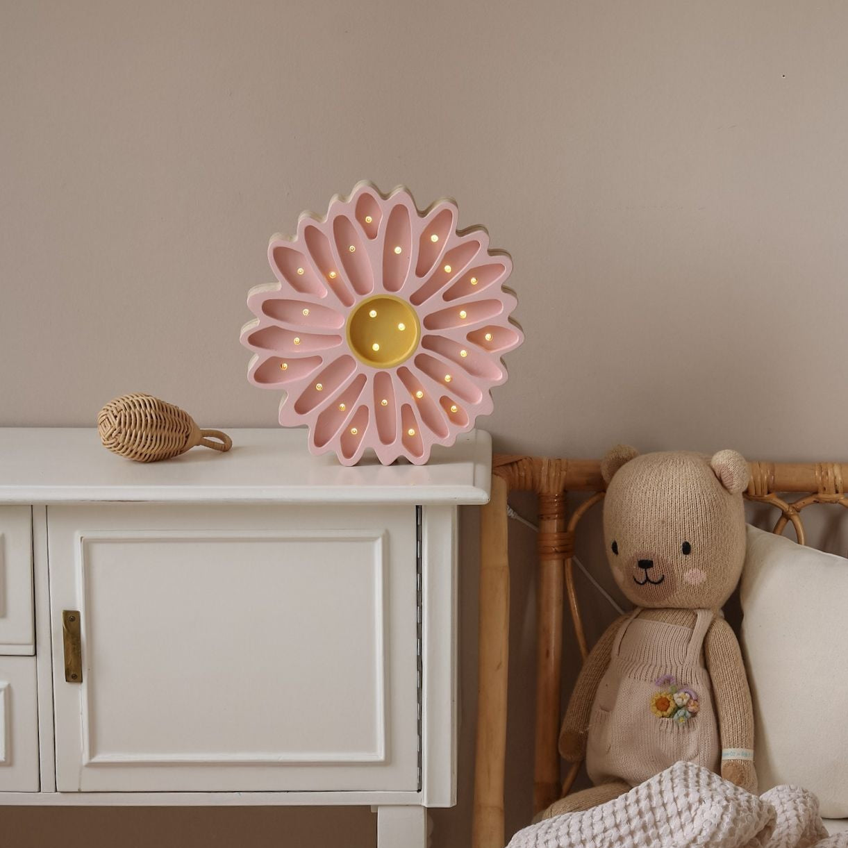 Little Lights Pink Flower Night Light glowing softly in by a bed in a girl's room