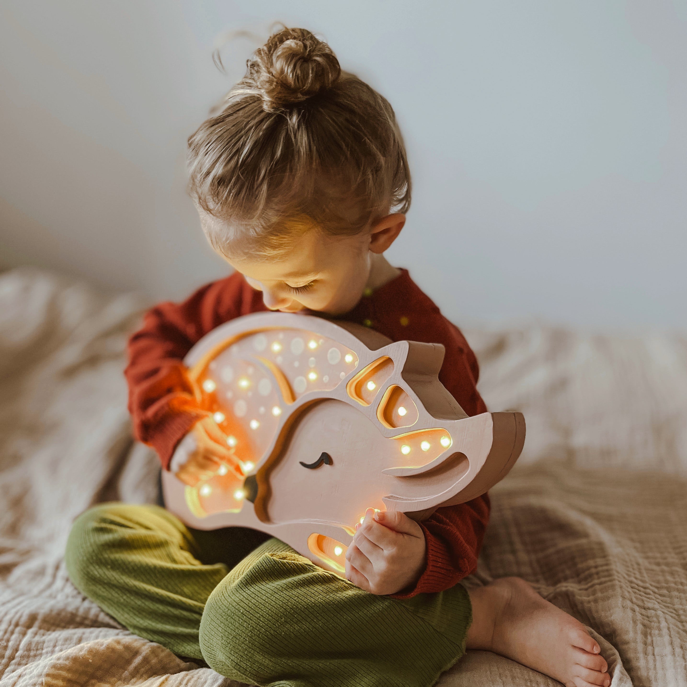 Baby Girl holding Little Lights Deer Lamp in her room