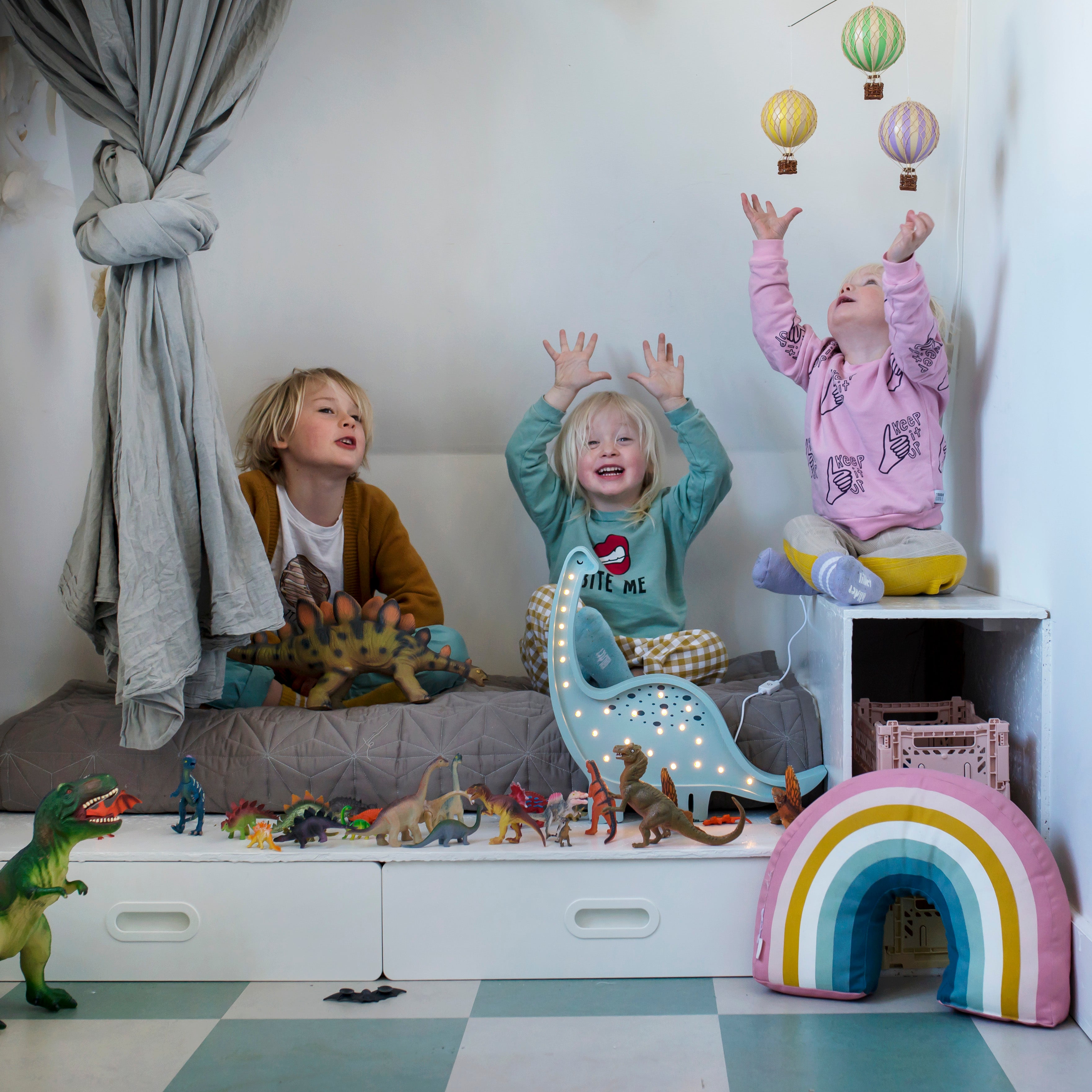 Little Lights Dino Diplodocus lamp in a dino theme kid's room with kids playing