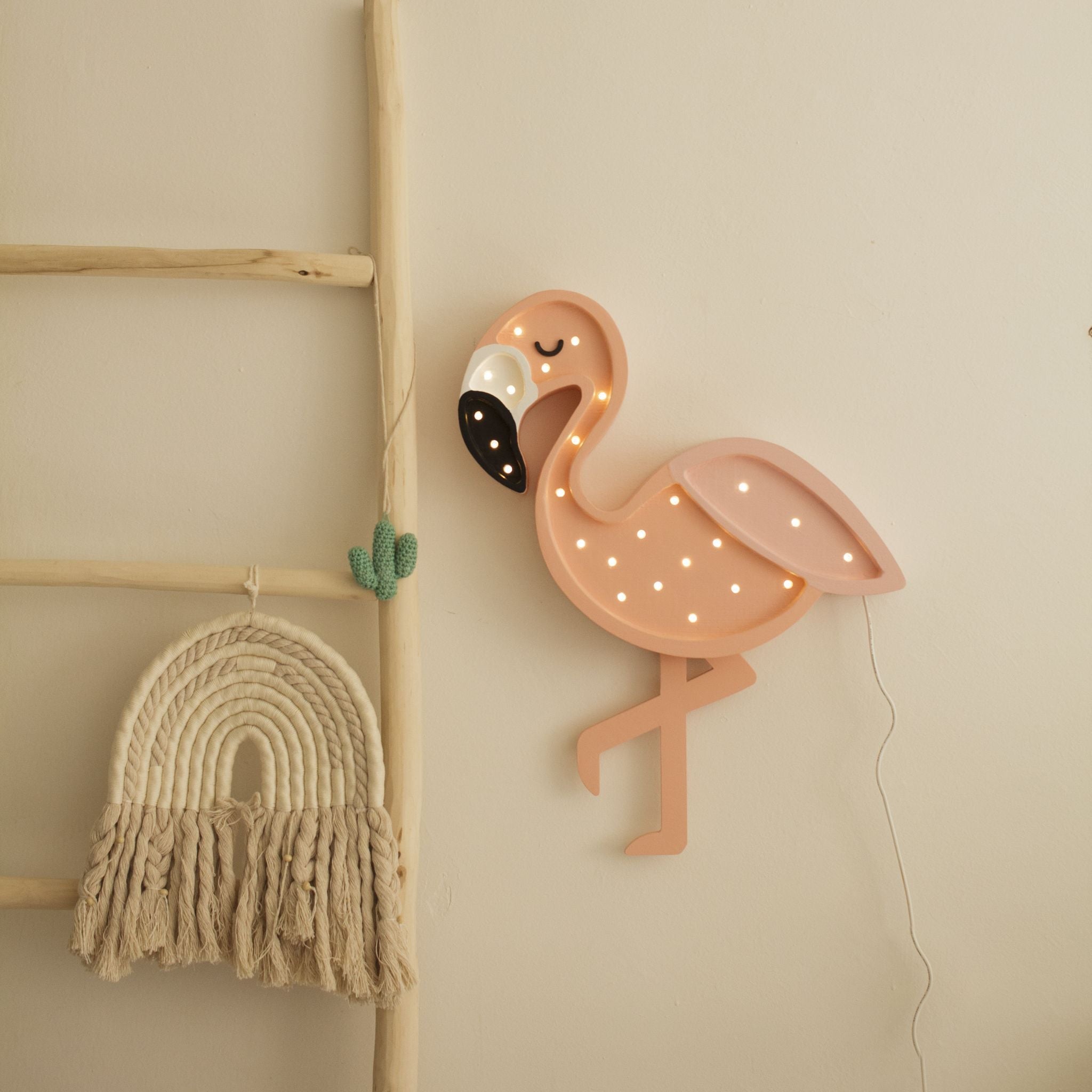 Little Lights Flamingo Lamp hanging on the wall in a kid's room