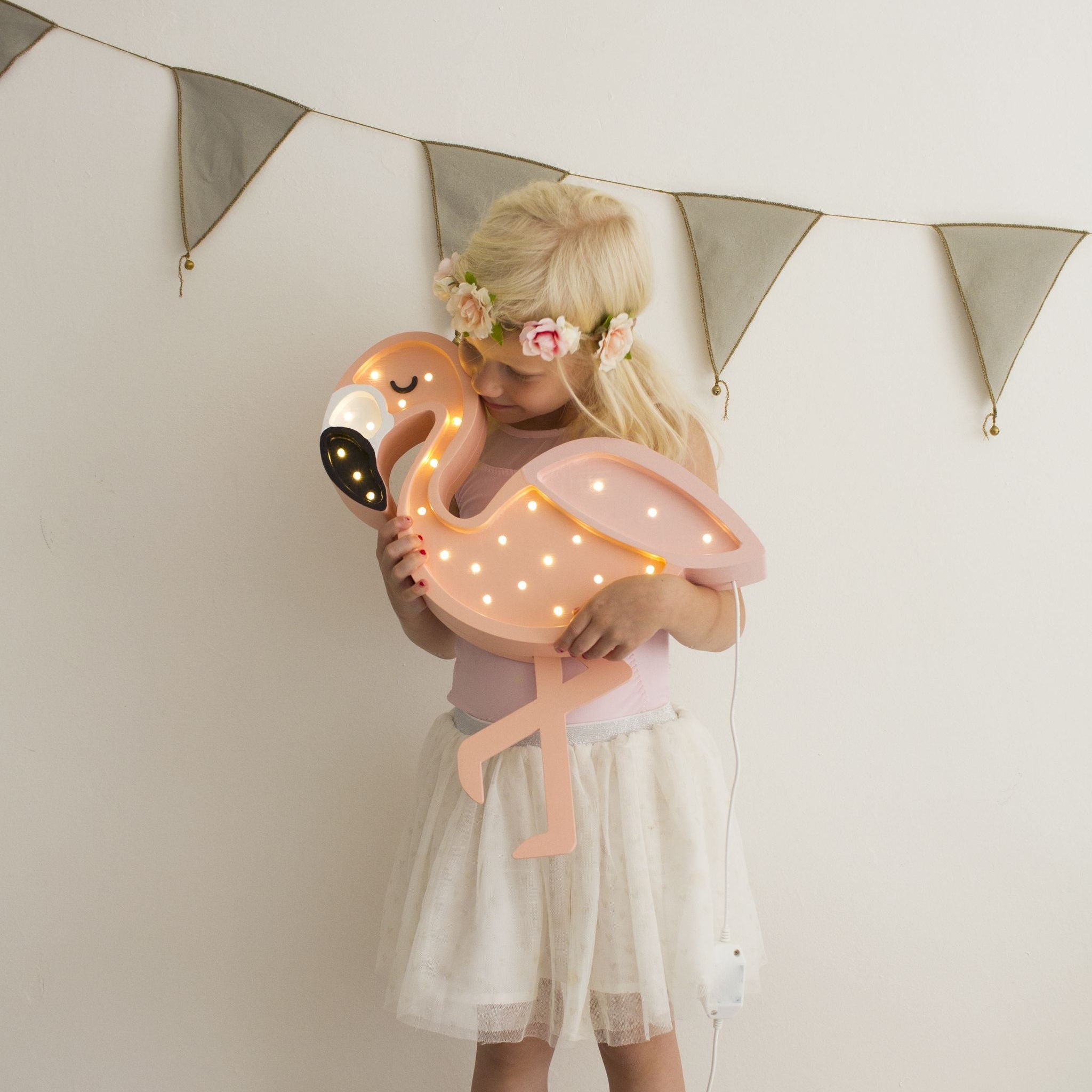 A girl holding Little Lights pink Flamingo Lamp