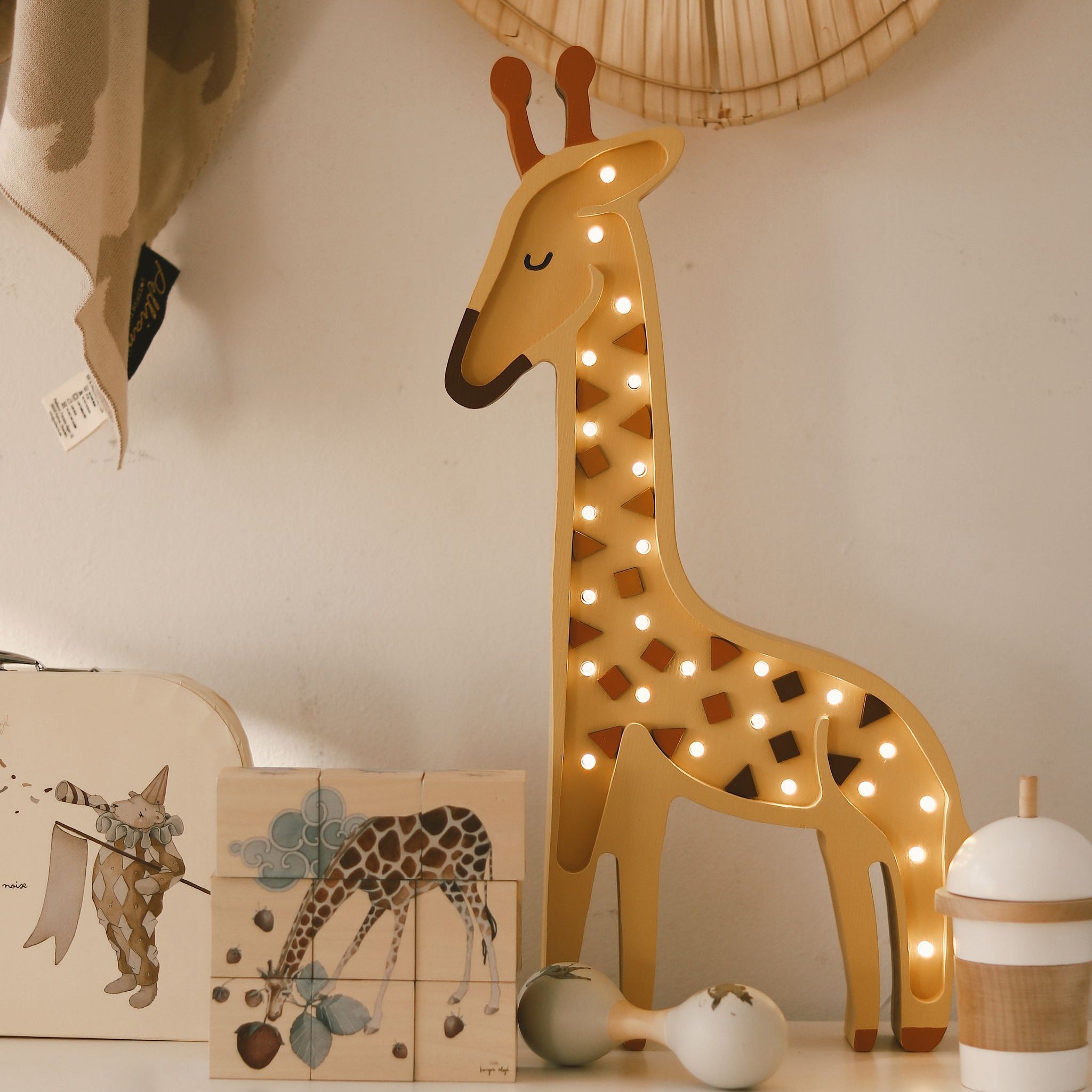 Little Lights yellow Giraffe Lamp on a dresser in a baby nursery