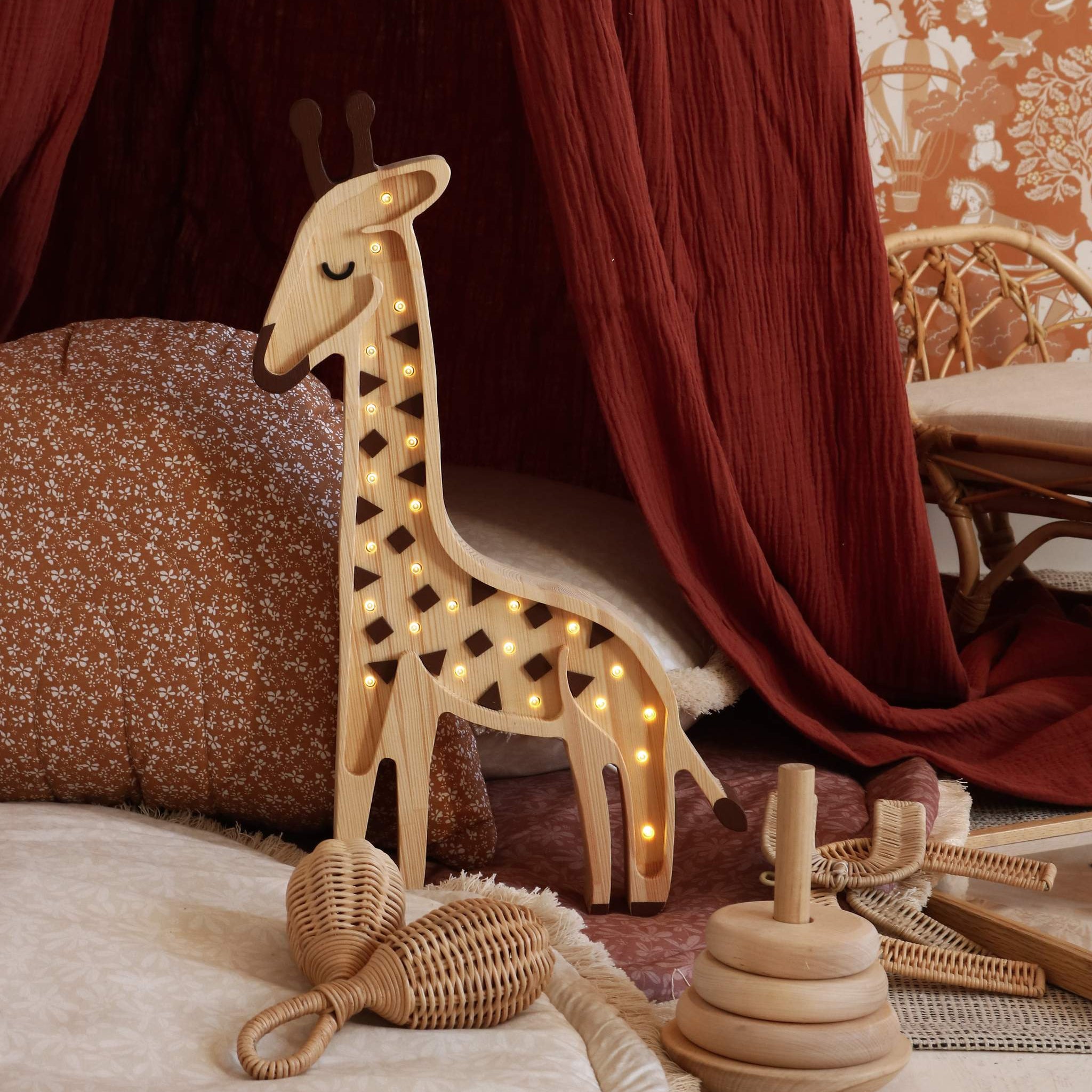 Wooden Little Lights Giraffe Lamp glowing softly in a girl's room