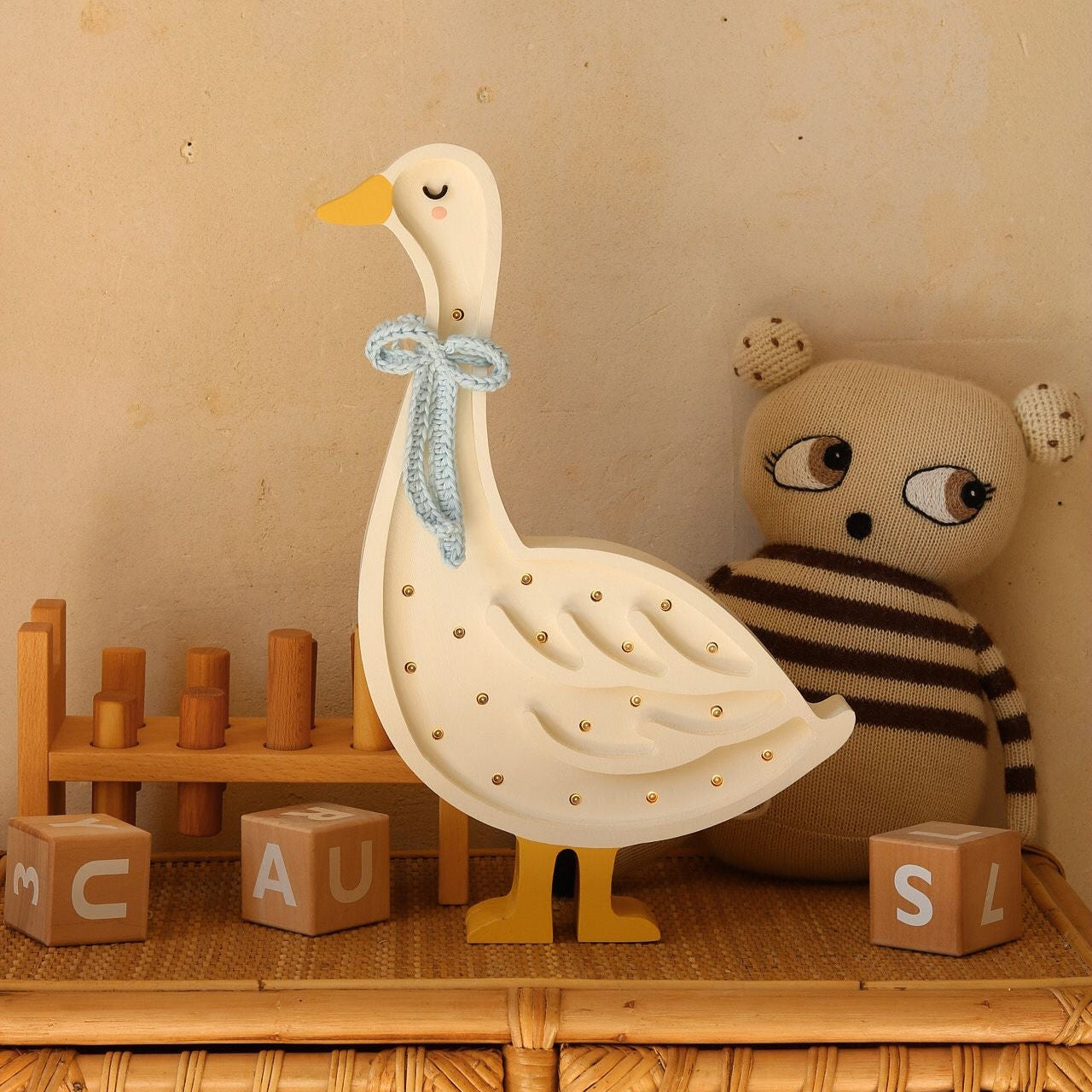 Little Lights Goose Lamp Blue Bow on a dresser in a baby nursery