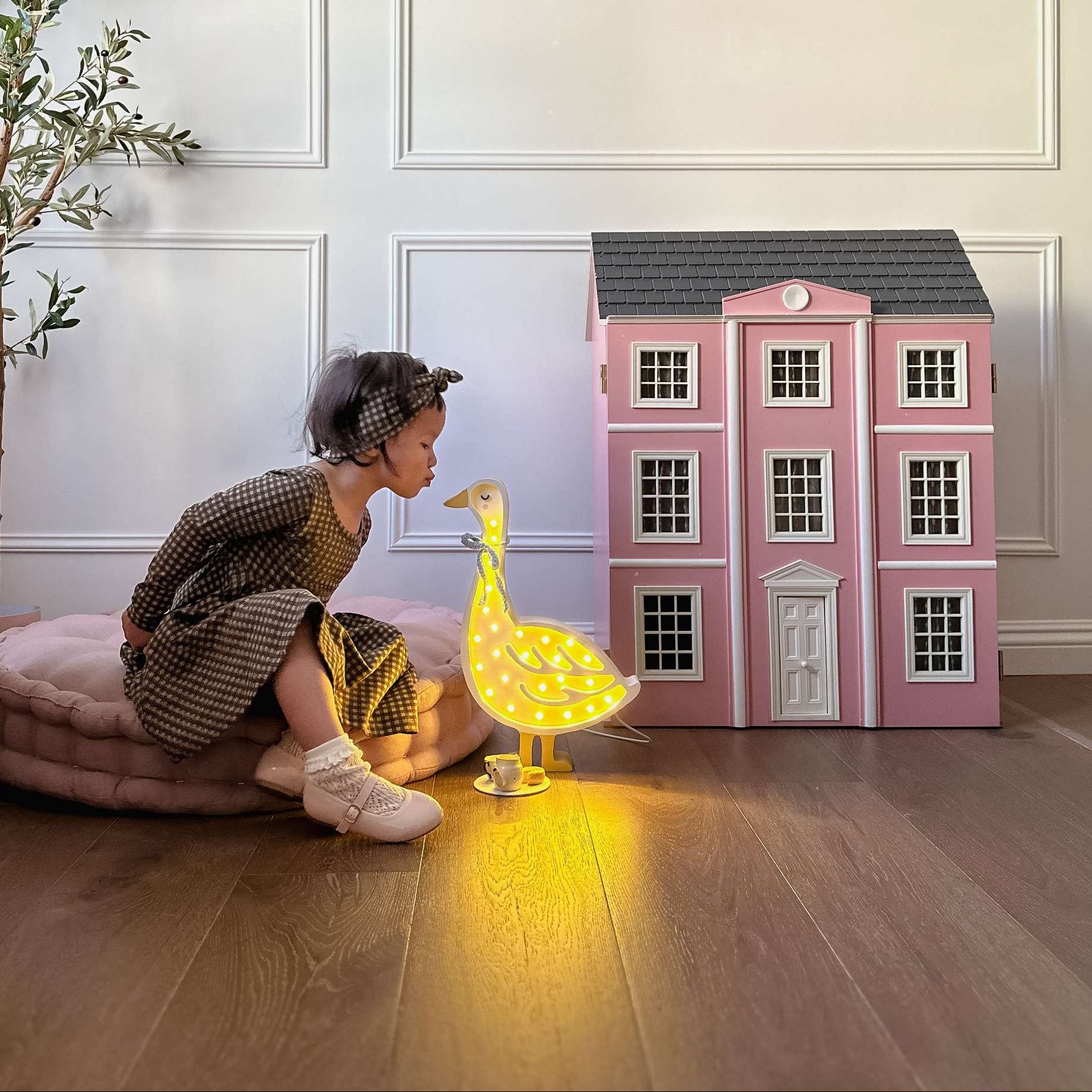 Baby girl playing next to the Little Lights Goose Lamp in a girl's room