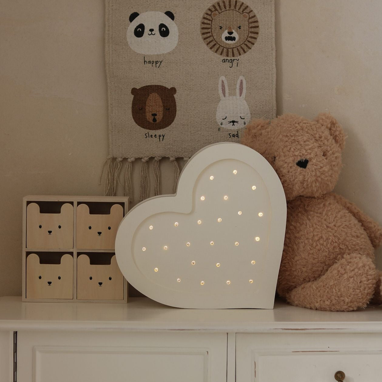 Little Lights Heart Lamp glowing softly on the dresser in a baby nursery