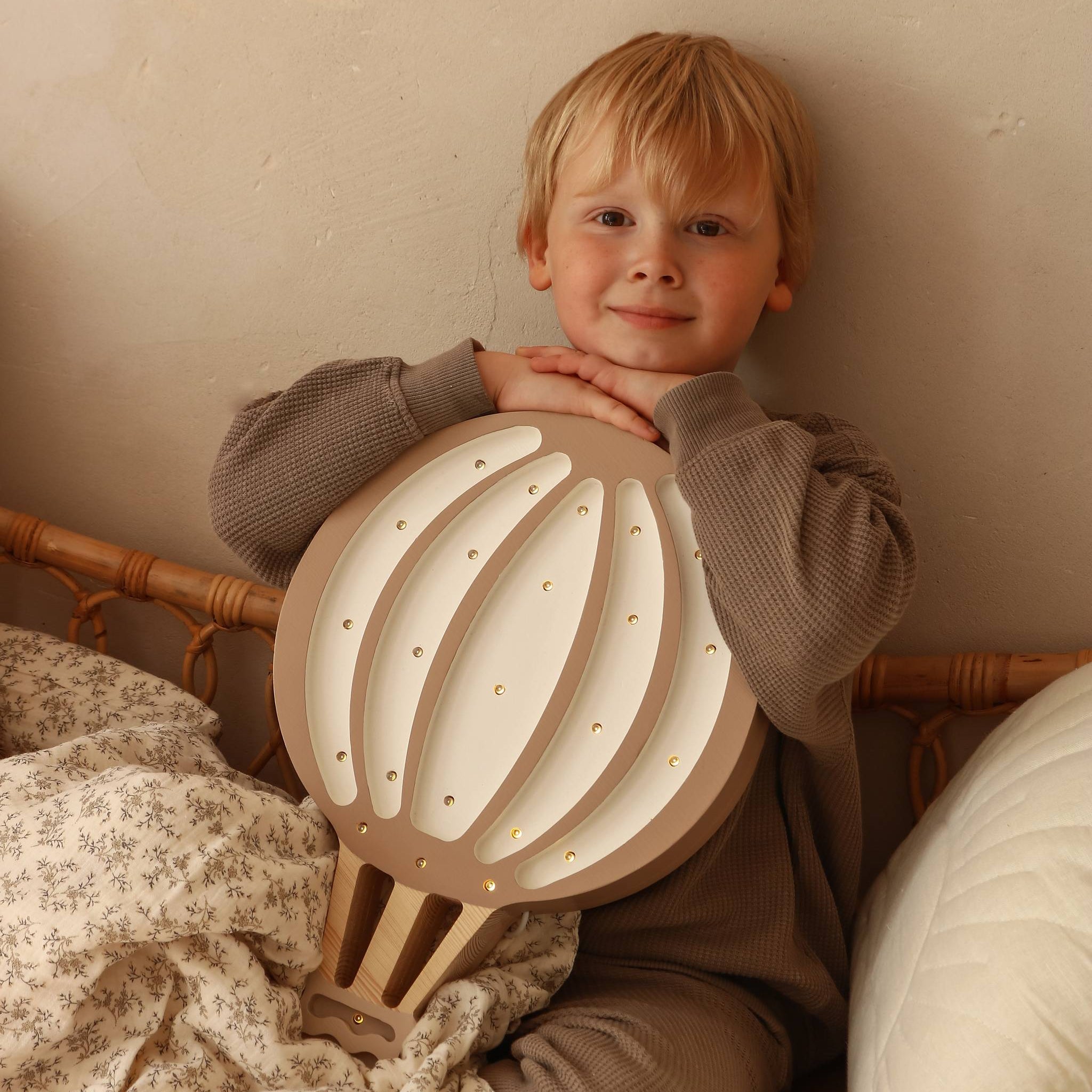 A boy holding Little Lights brown Hot Air Balloon Lamp