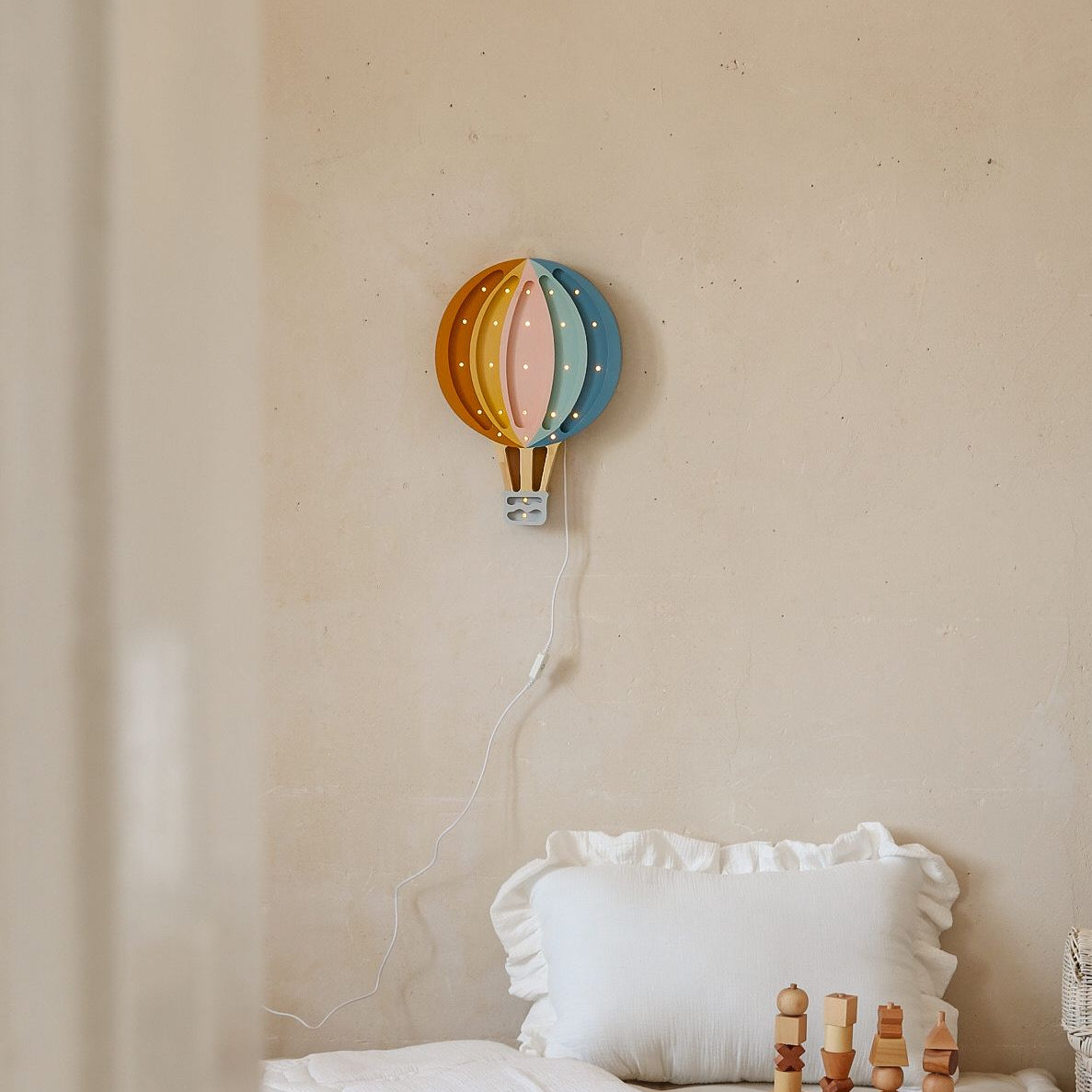 Little Lights Hot Air Balloon Retro Rainbow night light hung on the wall in a baby room