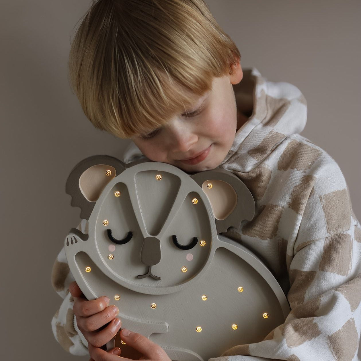 A boy holding Little Lights Koala Bear Lamp