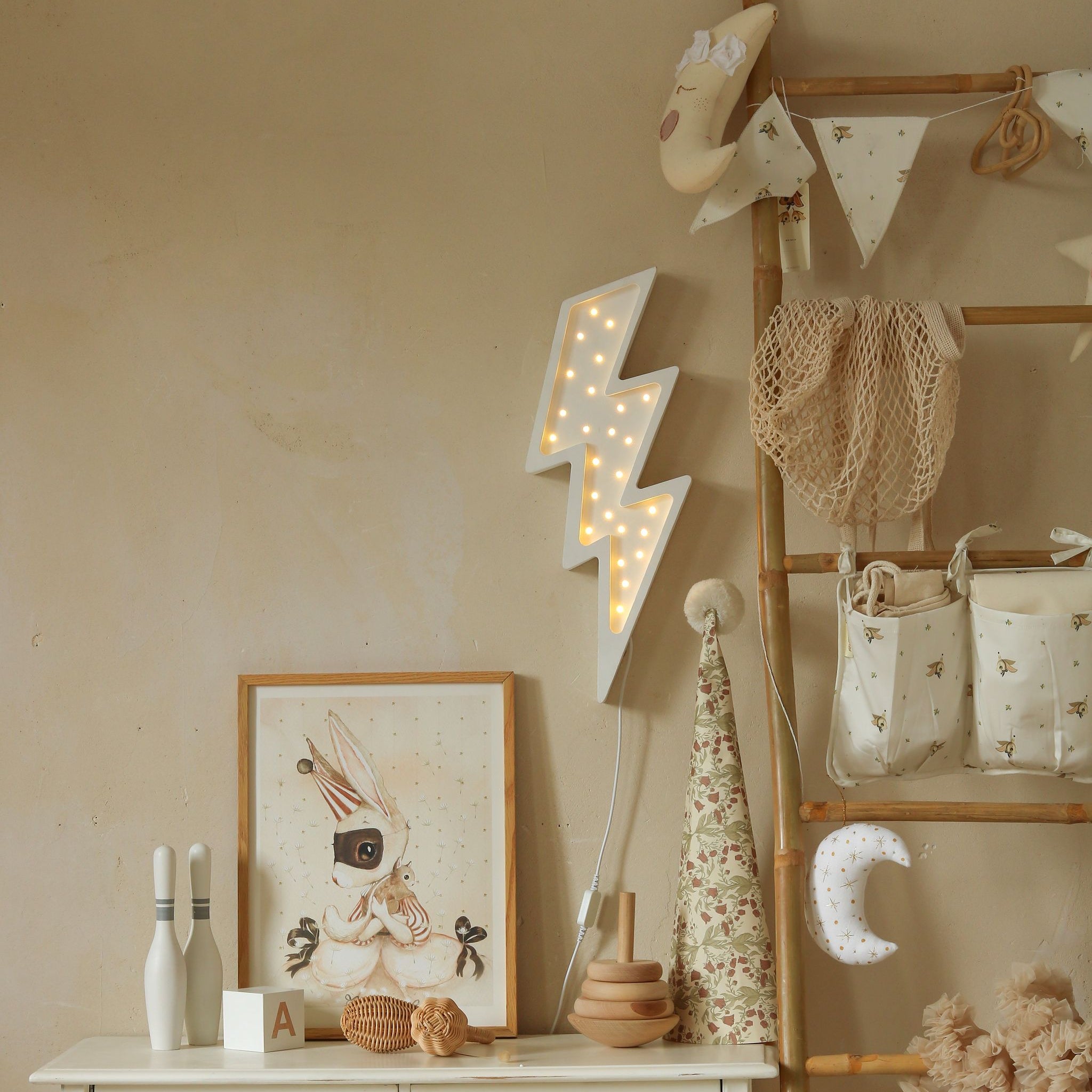 Little Lights white Lightning Bolt Lamp hanging above a dresser in a neutral baby nursery