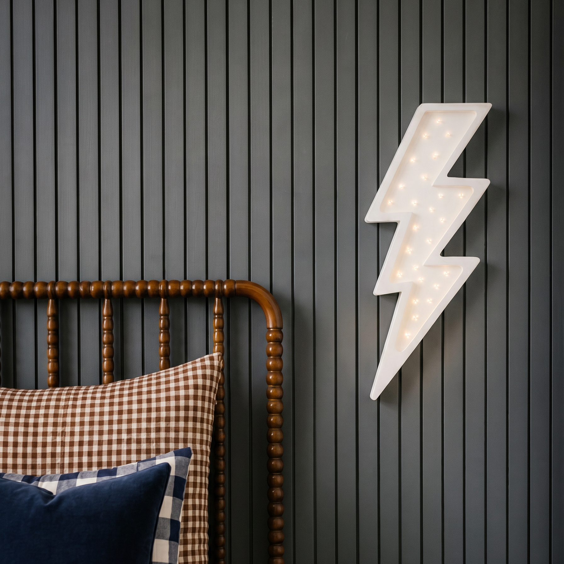 Little Lights white bolt night light next to the bed in a boy's room