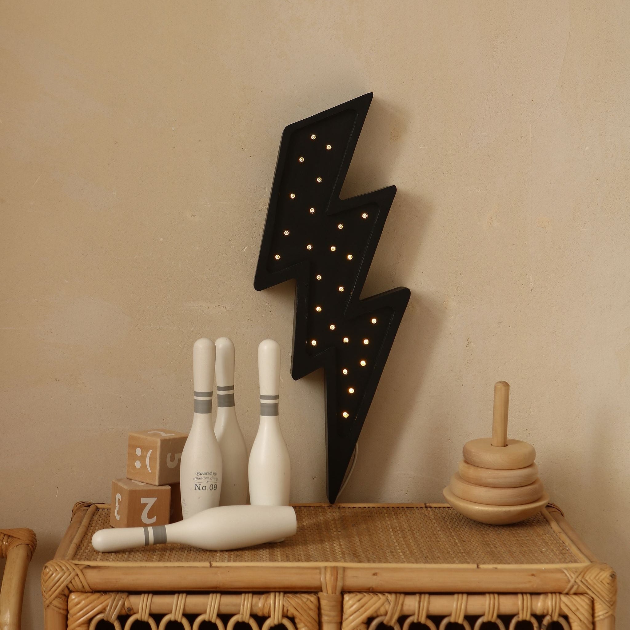 Little Lights black Lightning Bolt on the wall above the dresser in a baby room