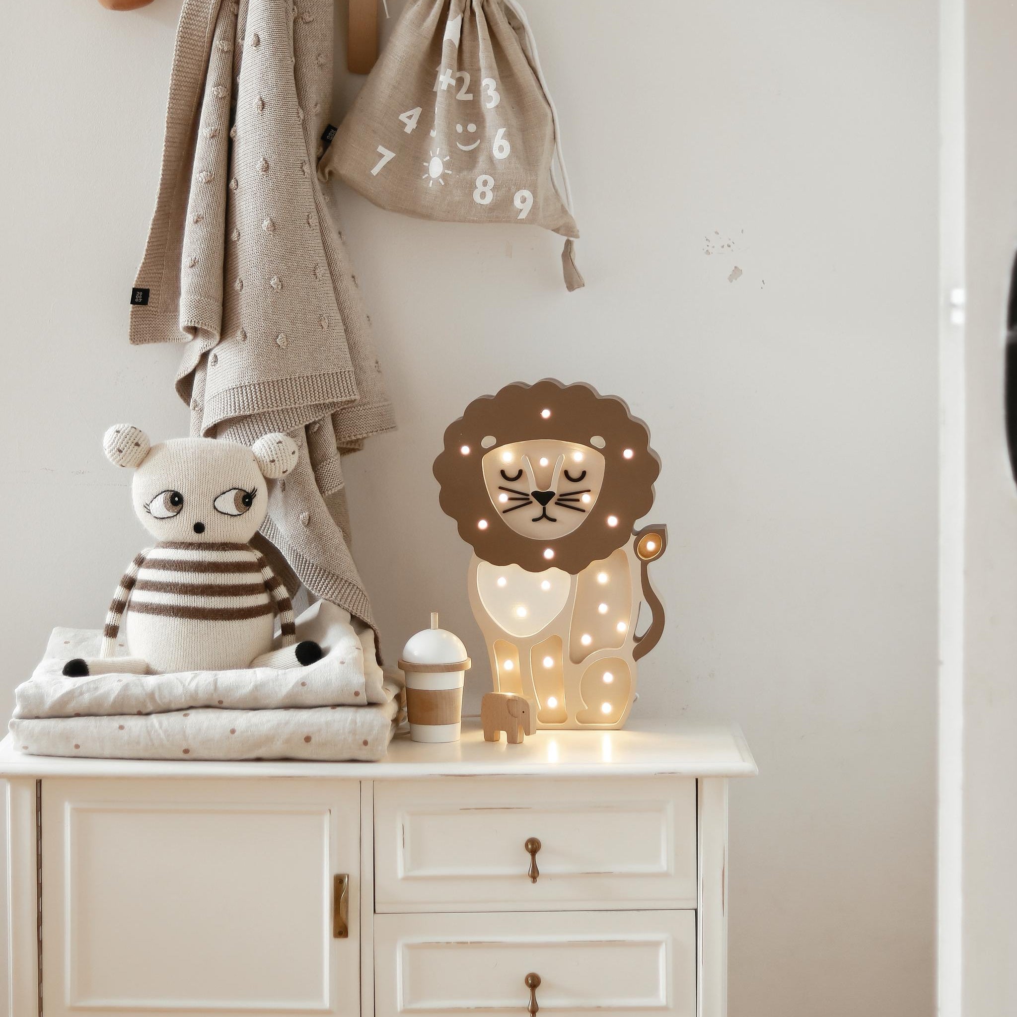 Little Light Beige Lion Night Light on a dresser in a baby nursery