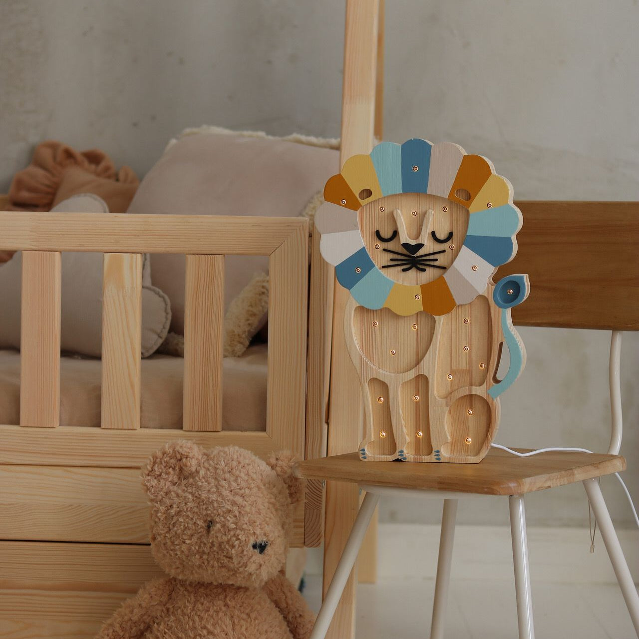 Wooden denim raiinbow Lion Lamp glowing by a kid's bed