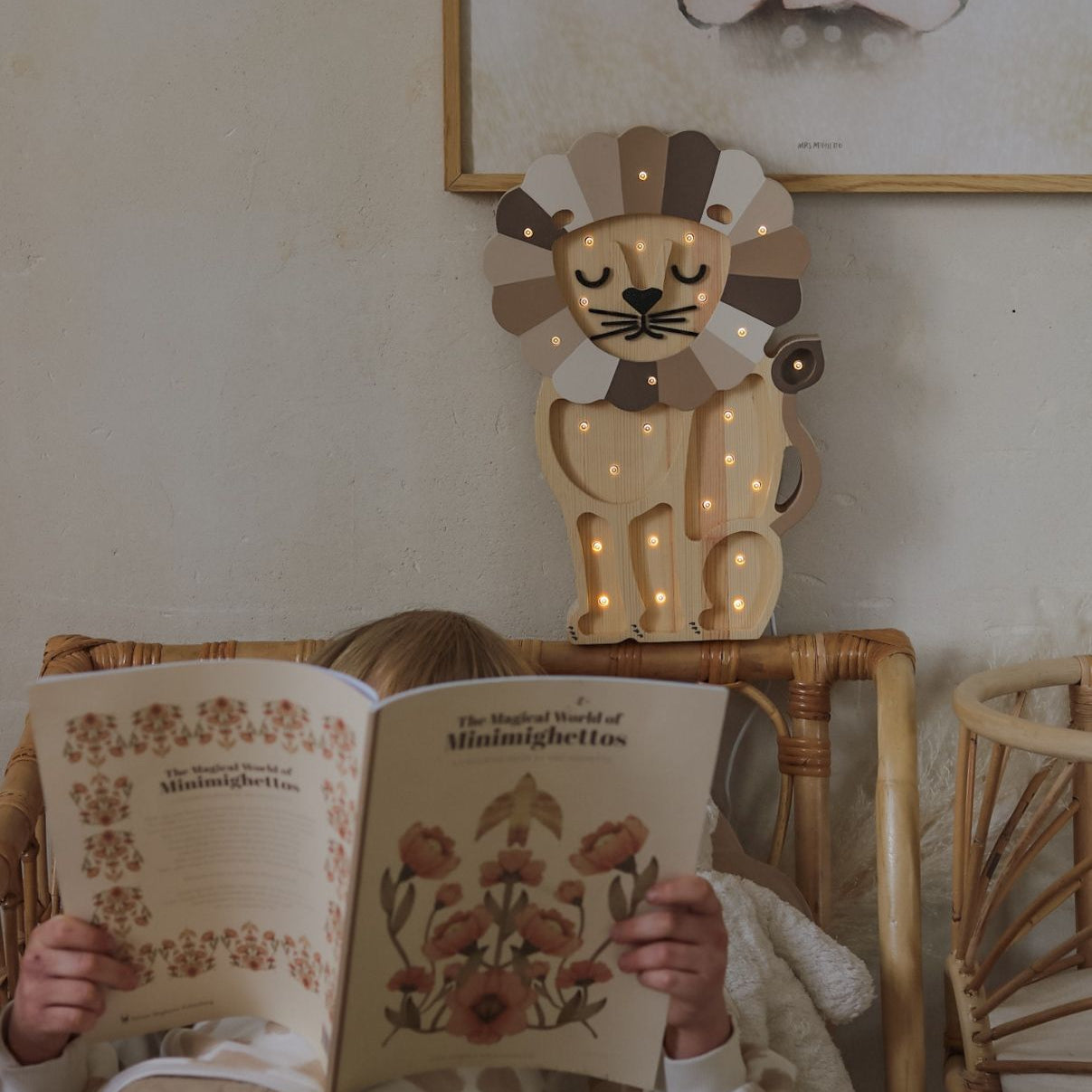 A boy reading in his bed by Little lights wooden Lion Lamp