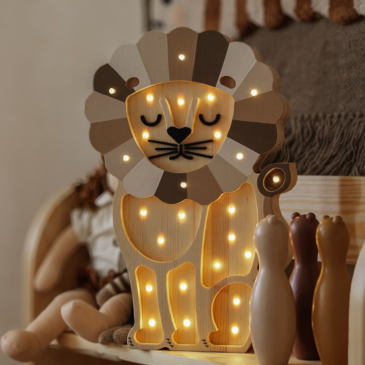 Wooden Lion night light glowing on a shelf in a aby room
