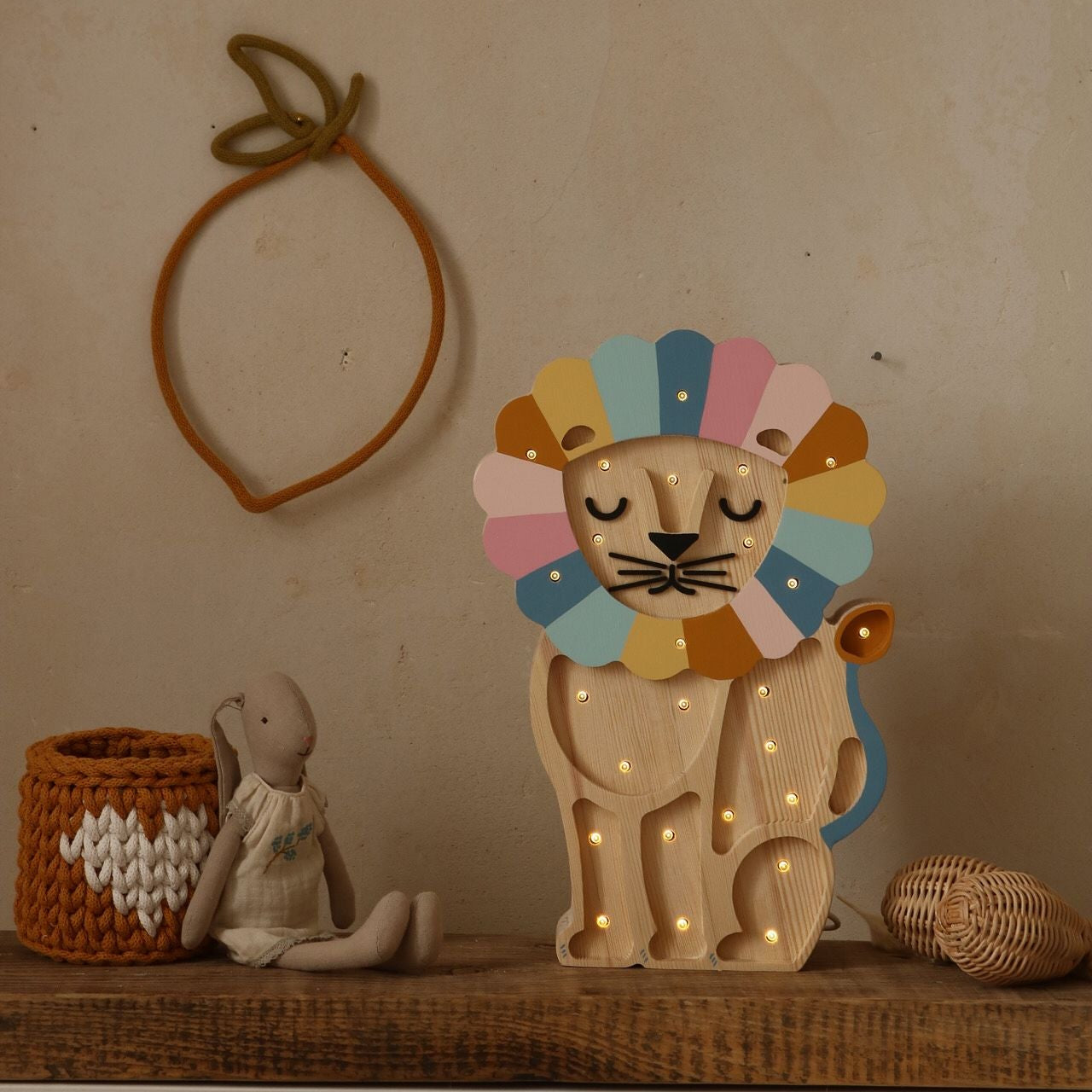 Little Lights Lion lamp with colorful mane on a dresser in a baby room