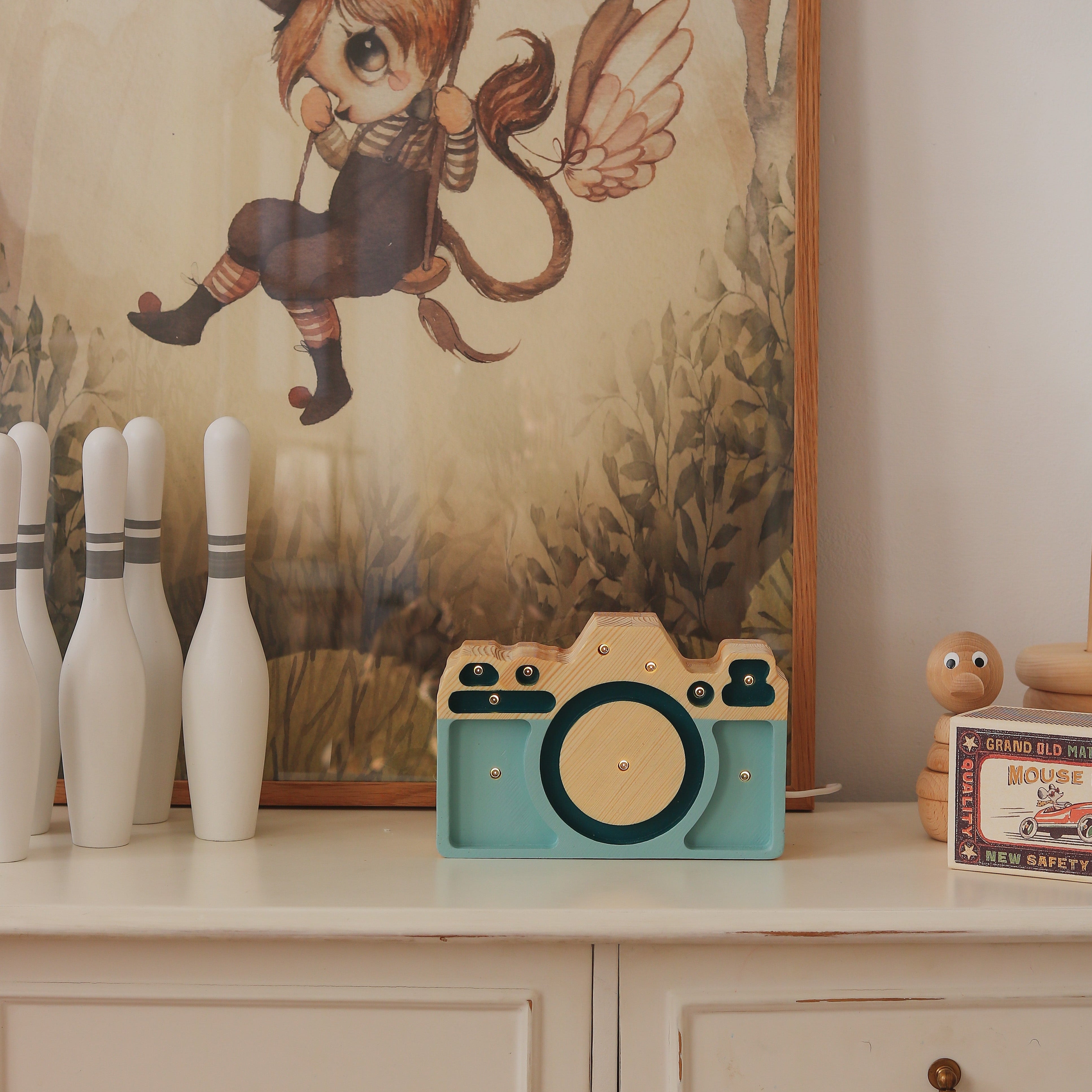 Little Lights teal Mini Camera Lamp on a dresser in a baby nursery