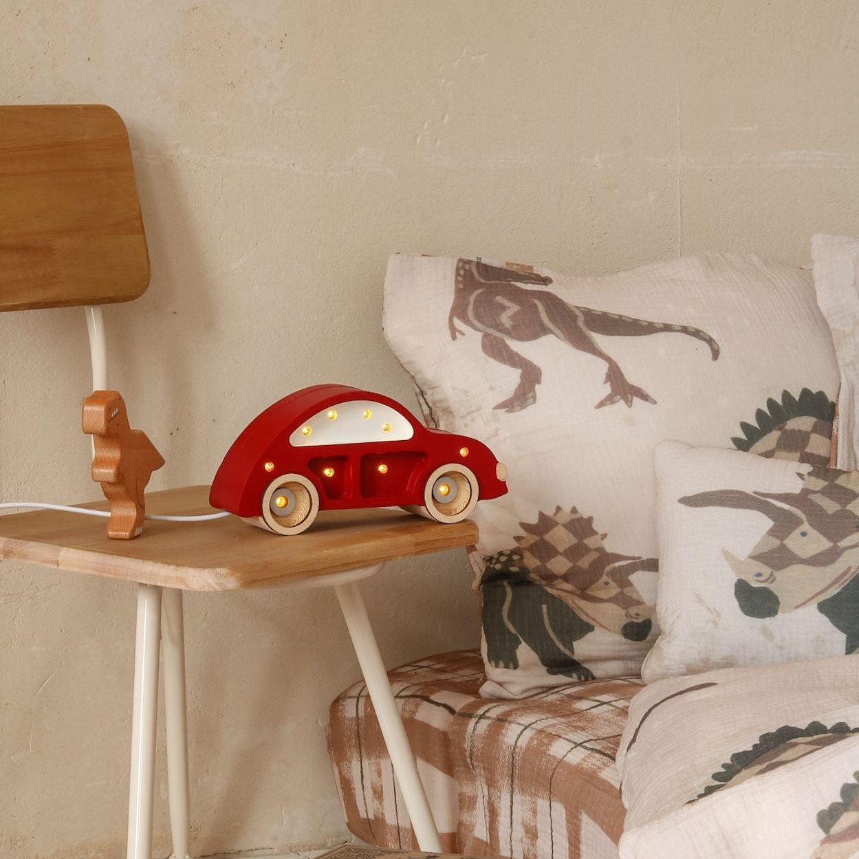 Little Lights red Mini Beetle Night Light in a boy's room glowing by the bed