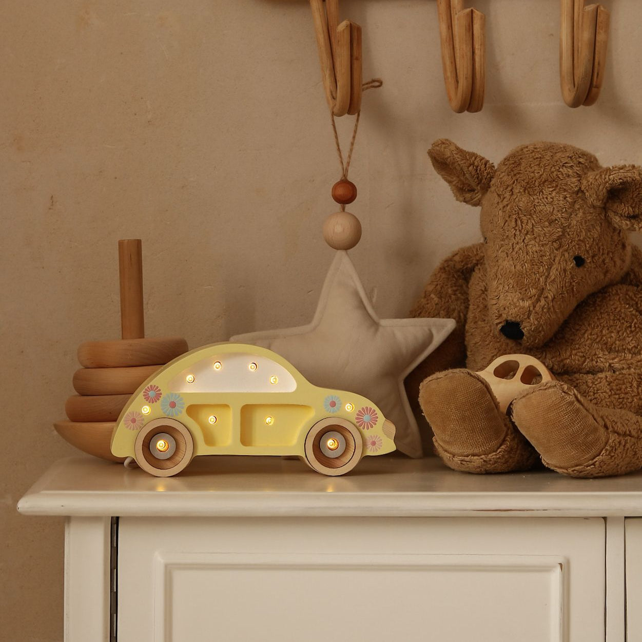 Little Lights yellow Mini Beetle Car Lamp glowing on a dresser in a baby room