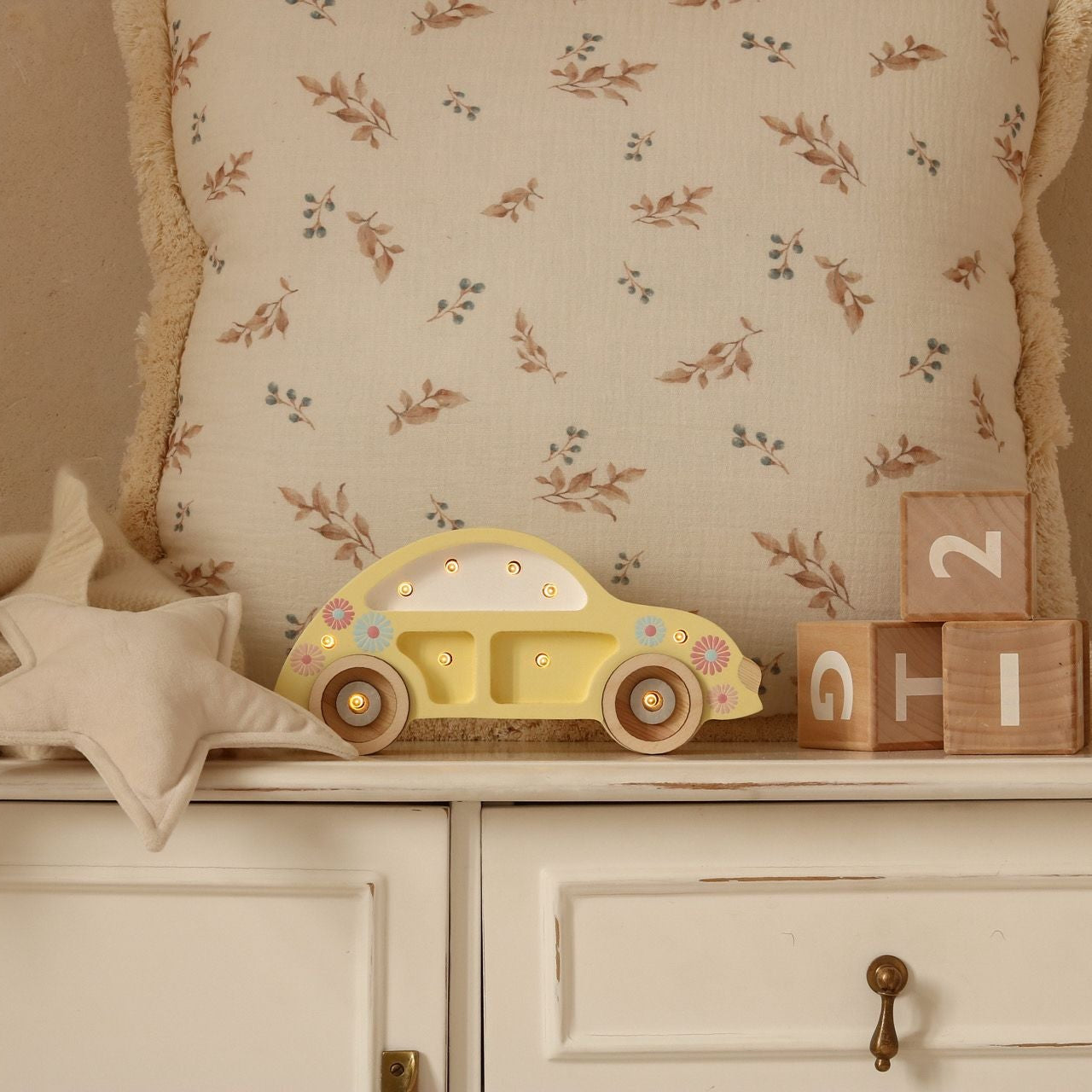Little Lights yellow Mini Beetle Car night light on a dresser in a baby nursery