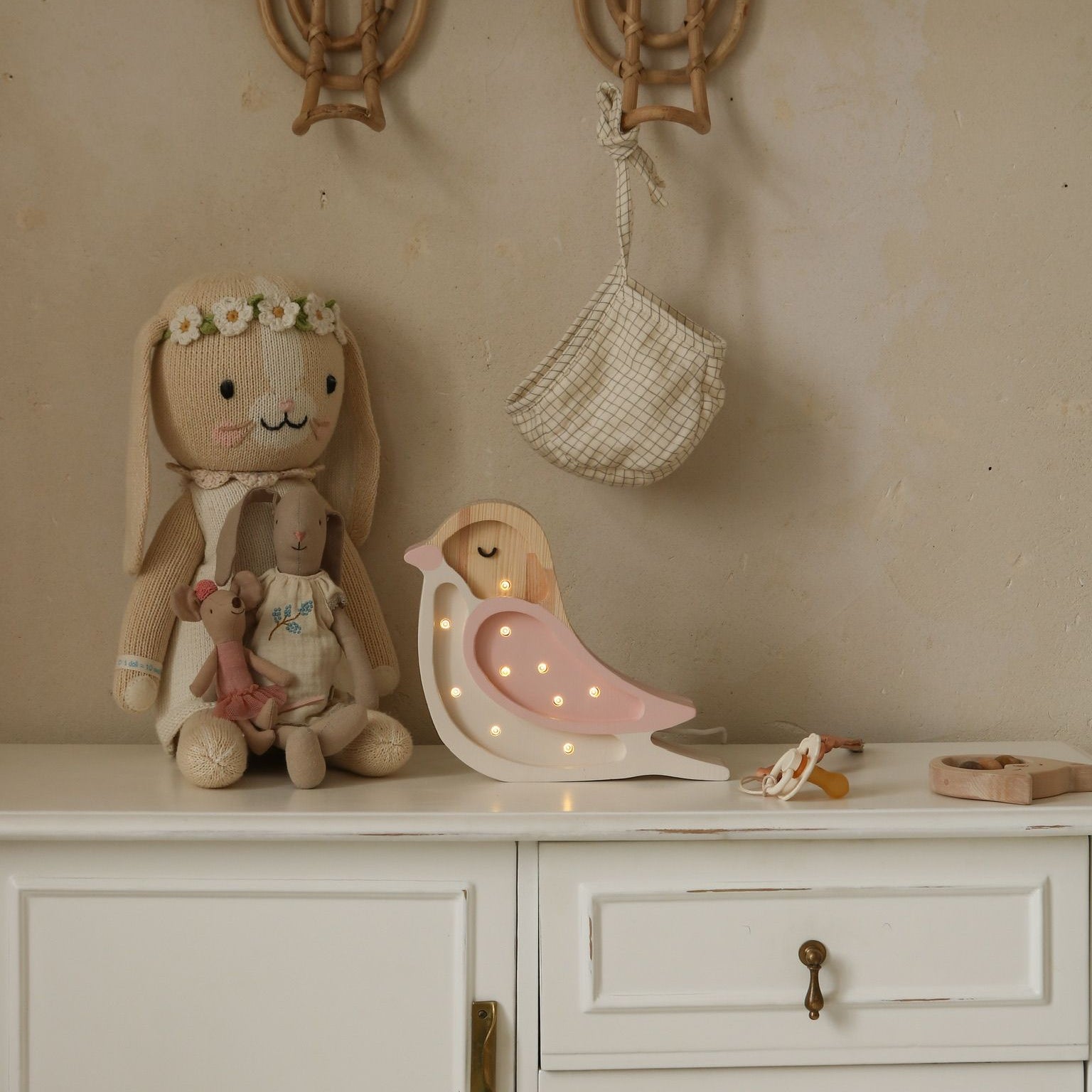 Little Lights Mini Bird pink Lamp on a dresser in a. baby girl room