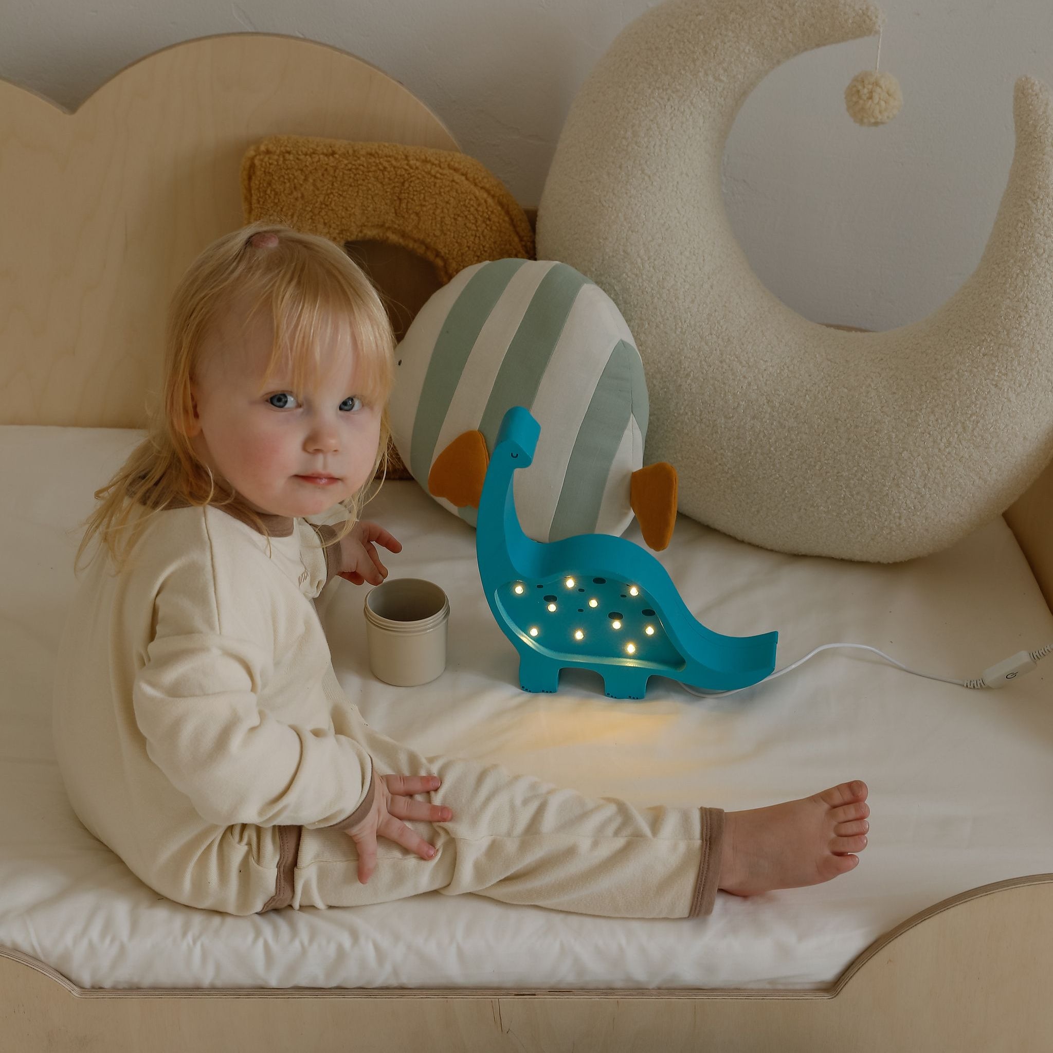 Baby girl playing in her bedroom by the Mini dino Lamp
