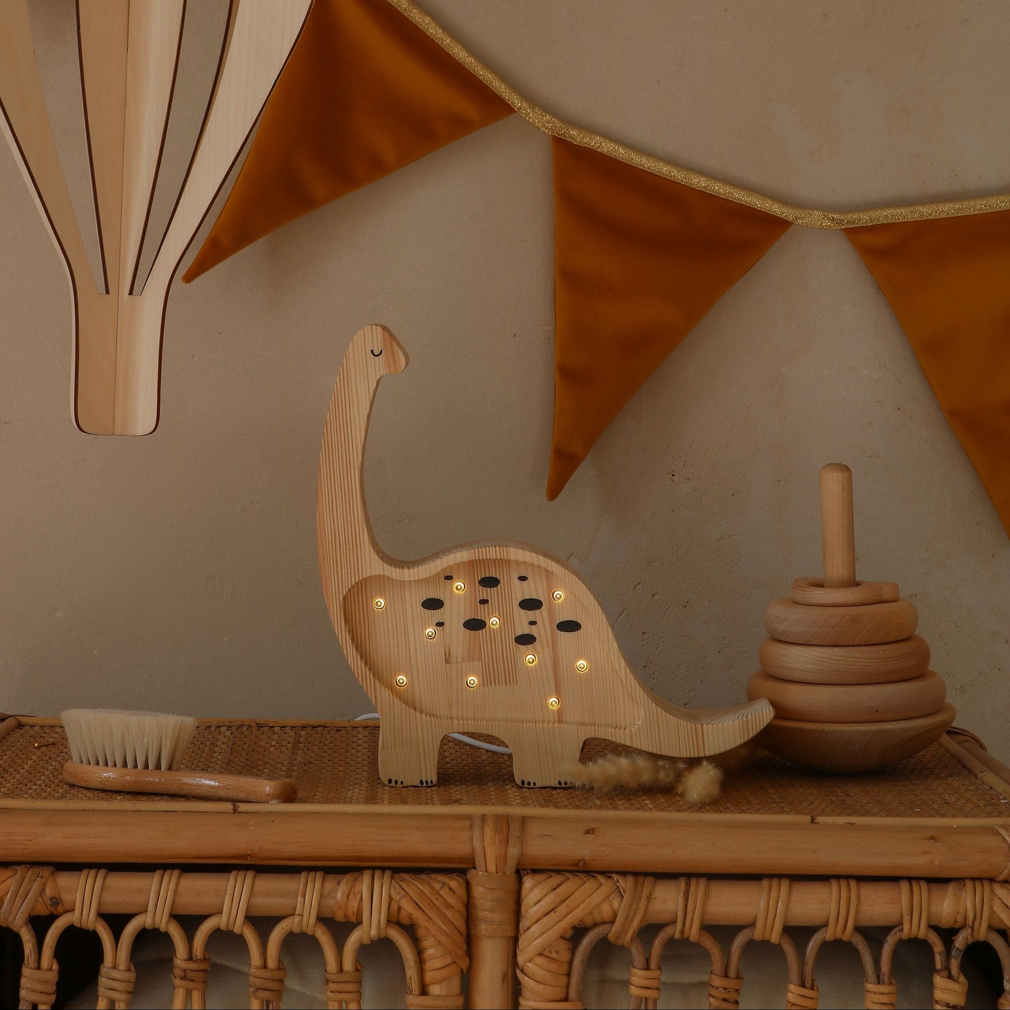 Wooden handmade Dino Lamp on a dresser in a baby nursery