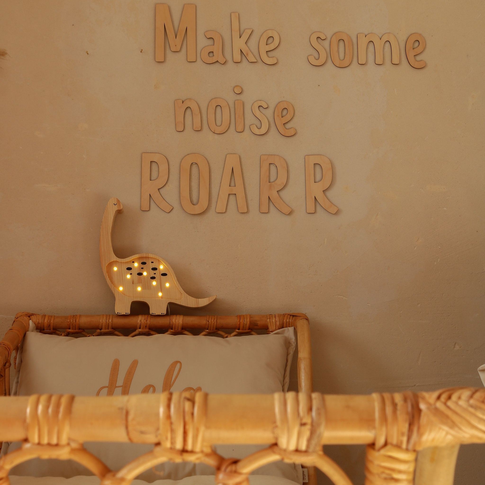 Little Lights wooden Mini Dino night light glowing by the bed in a boy's room