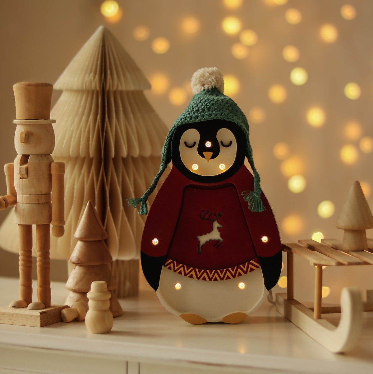 Little Lights Red Penguin Lamp in a cute crochet hat on a dresser next to Holiday Decorations