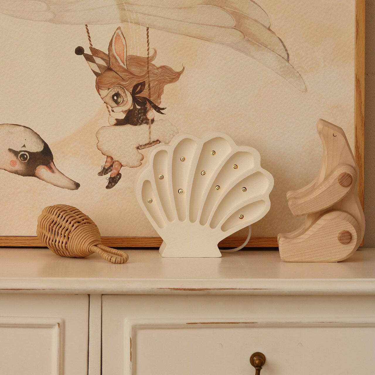 White Seashell night light glowing on a dresser in a baby nursery