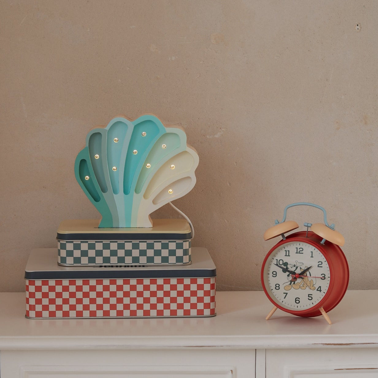 Light Blue Seashell Lamp by Little Lights glowing softly on a dresser in a kids room