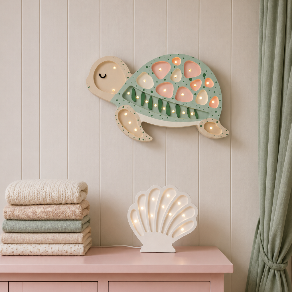 A styled nursery with a pink dresser, a glowing white Shell lamp, and a decorative wooden turtle lamp hanging on a white paneled wall.