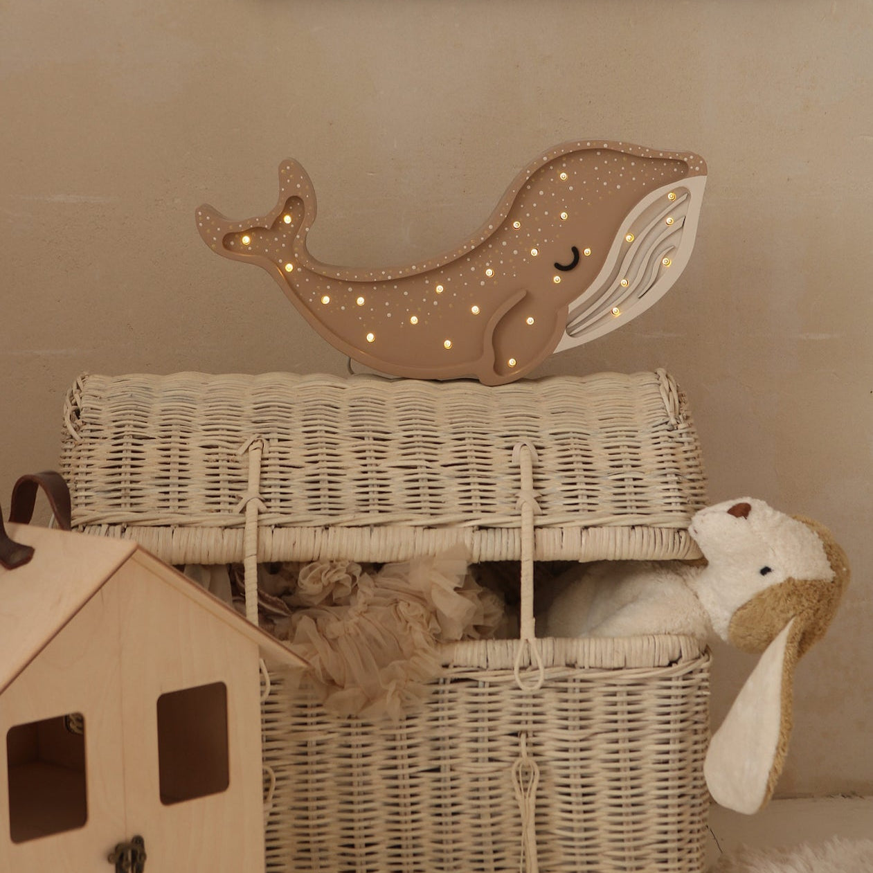 Brown Whale Lamp on a wicker toy chest in a baby room