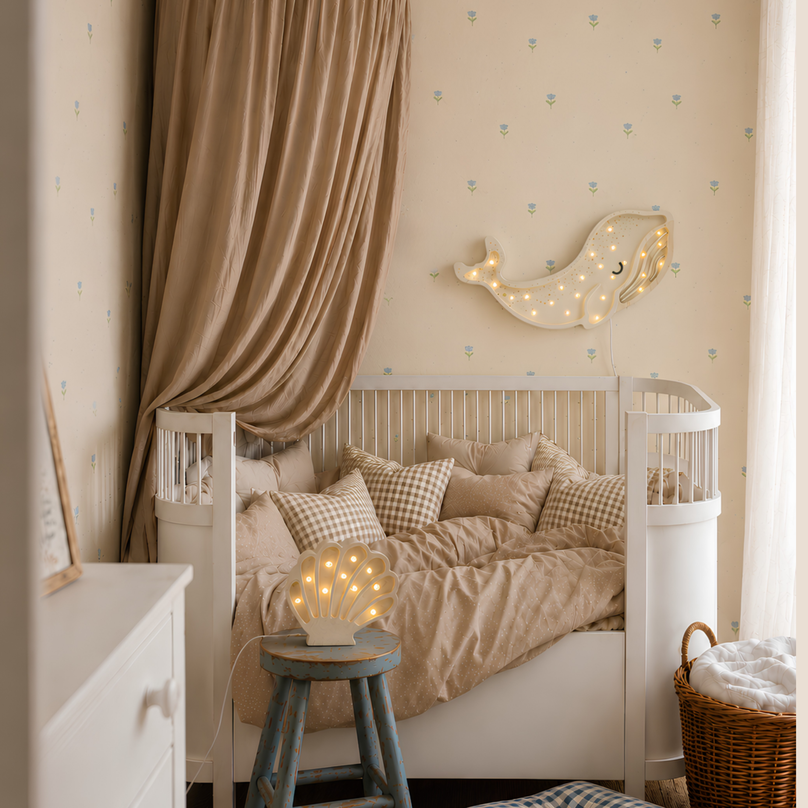 White Whale Lamp hanging above the toddler bed with the Mini Seashell Lamp glowing on the side in a baby nursery